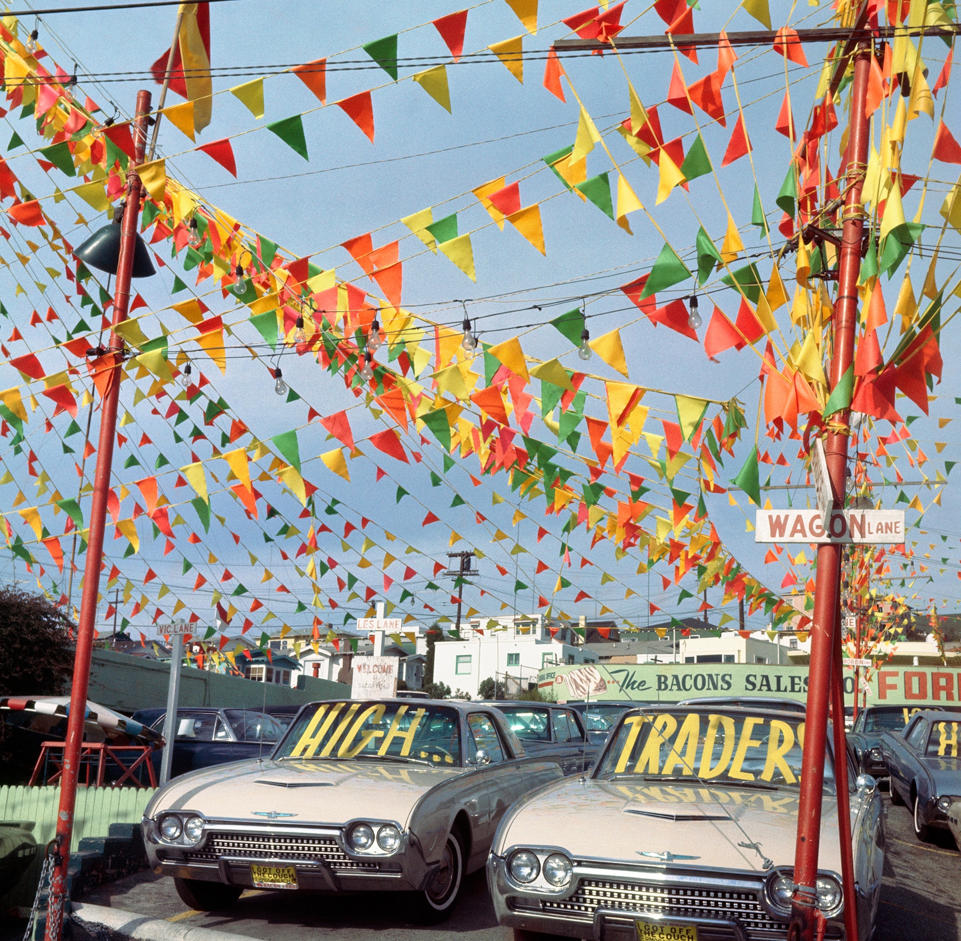 Colorful triangular flags strung above a car dealership.