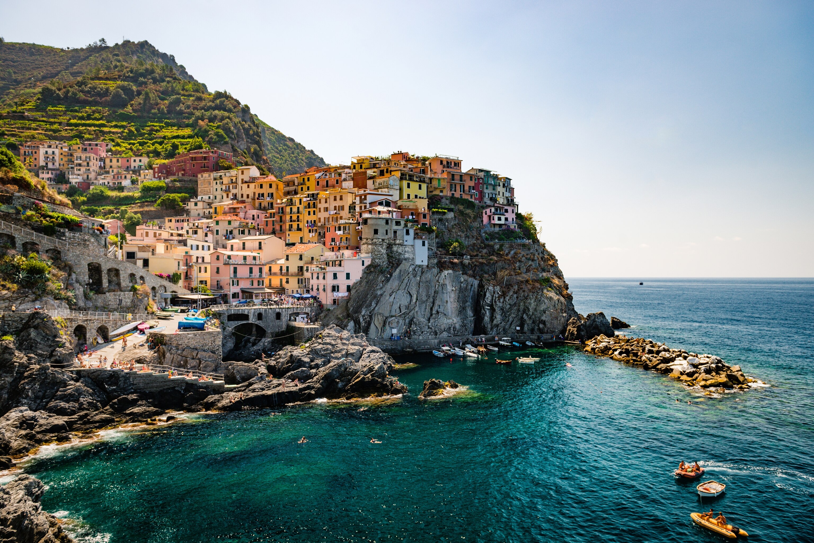 colourful homes lining the sides of the cliffs at the small harbor in Manarola, Italy