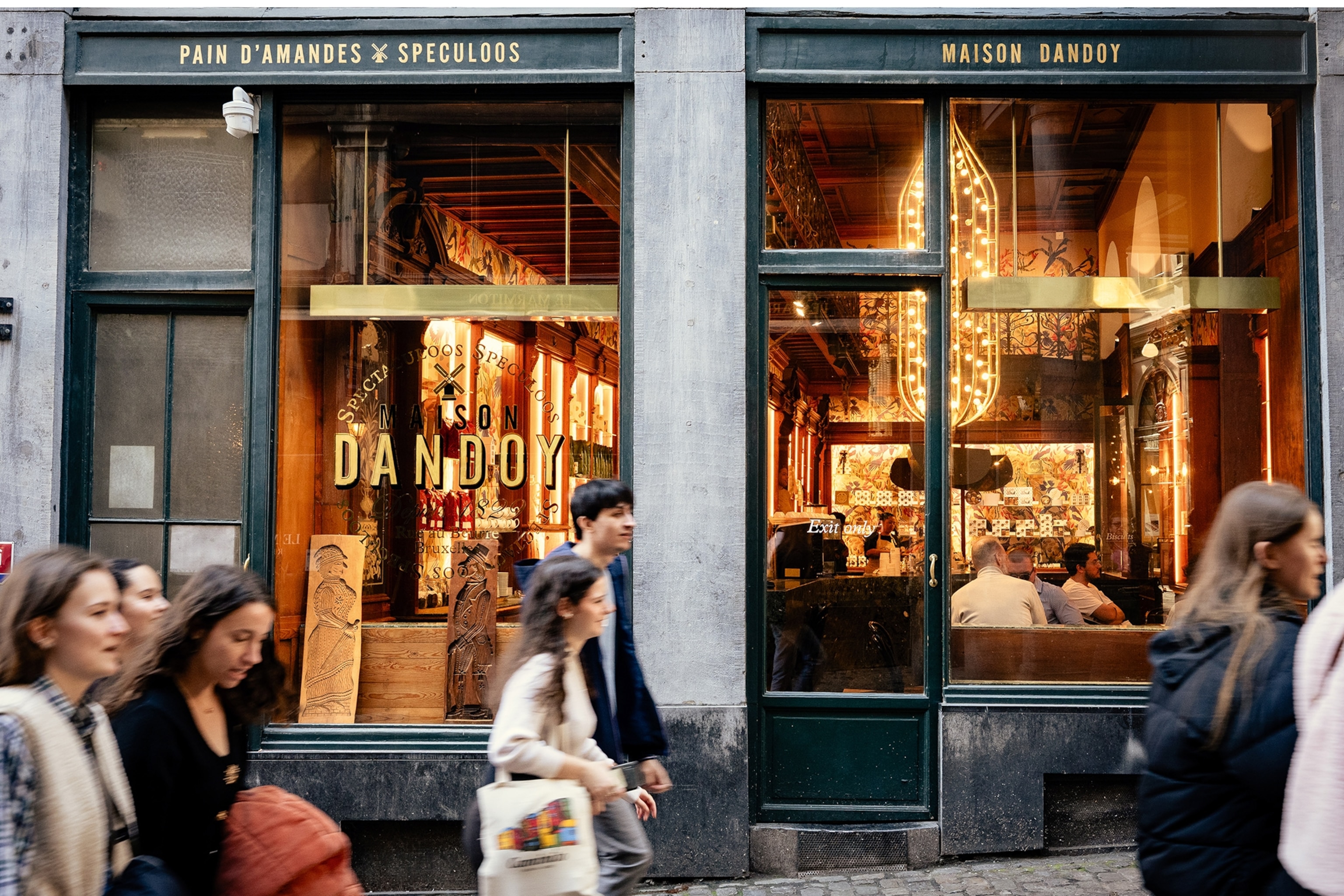 People walk past a restaurant.