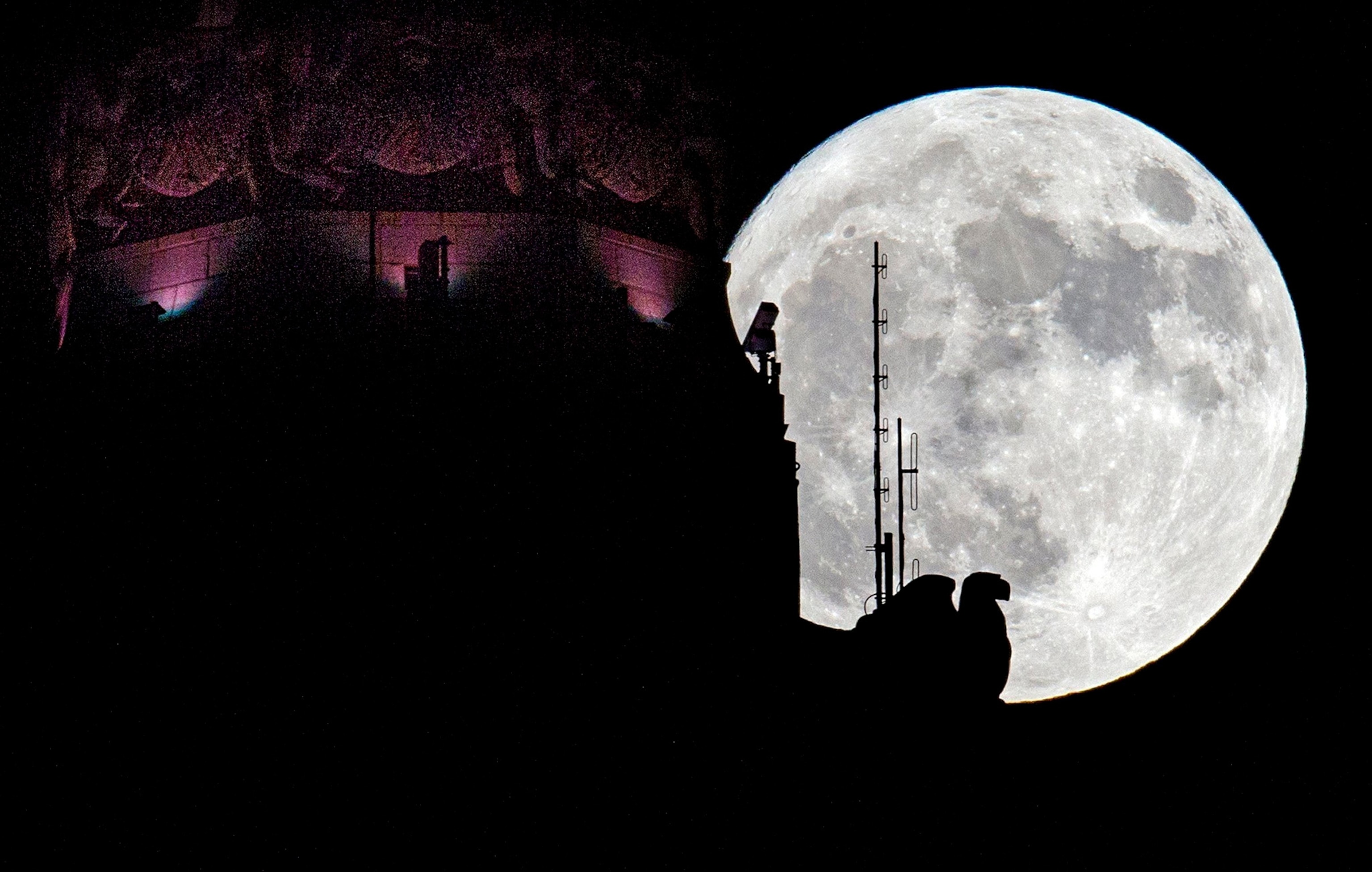 moon rises behind the eagle sculpture high atop LeVeque Tower in Columbus, Ohio