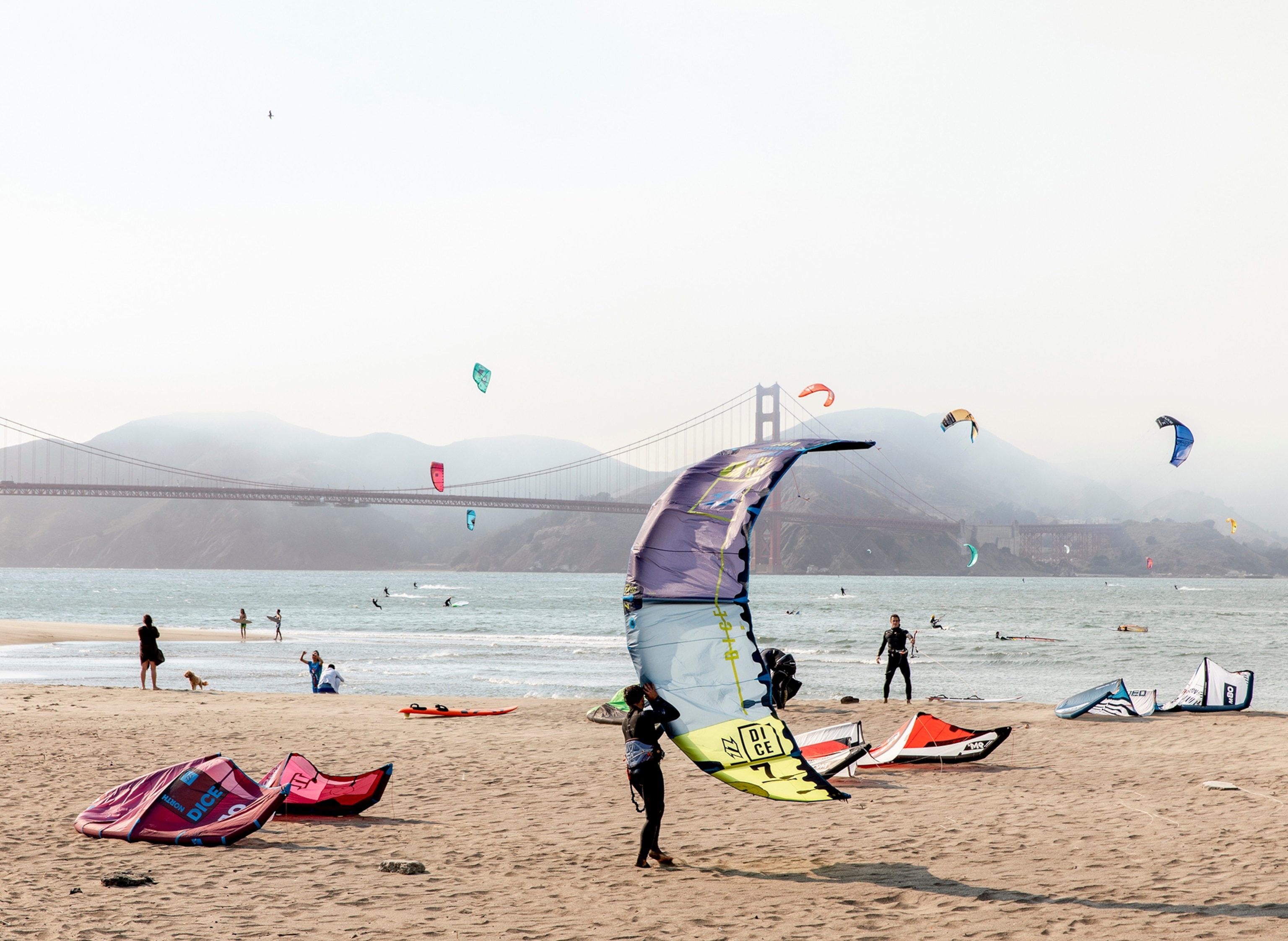 Kitesurfers prepare to launch at Crissy Field at the foot of the historic Presidio in San Francisco, Calif., Aug. 20, 2020. With the virus lingering and modified lockdowns still in effect, San Franciscans can still get an adrenaline rush watching kitesurfing daredevils catch air off Crissy Field.