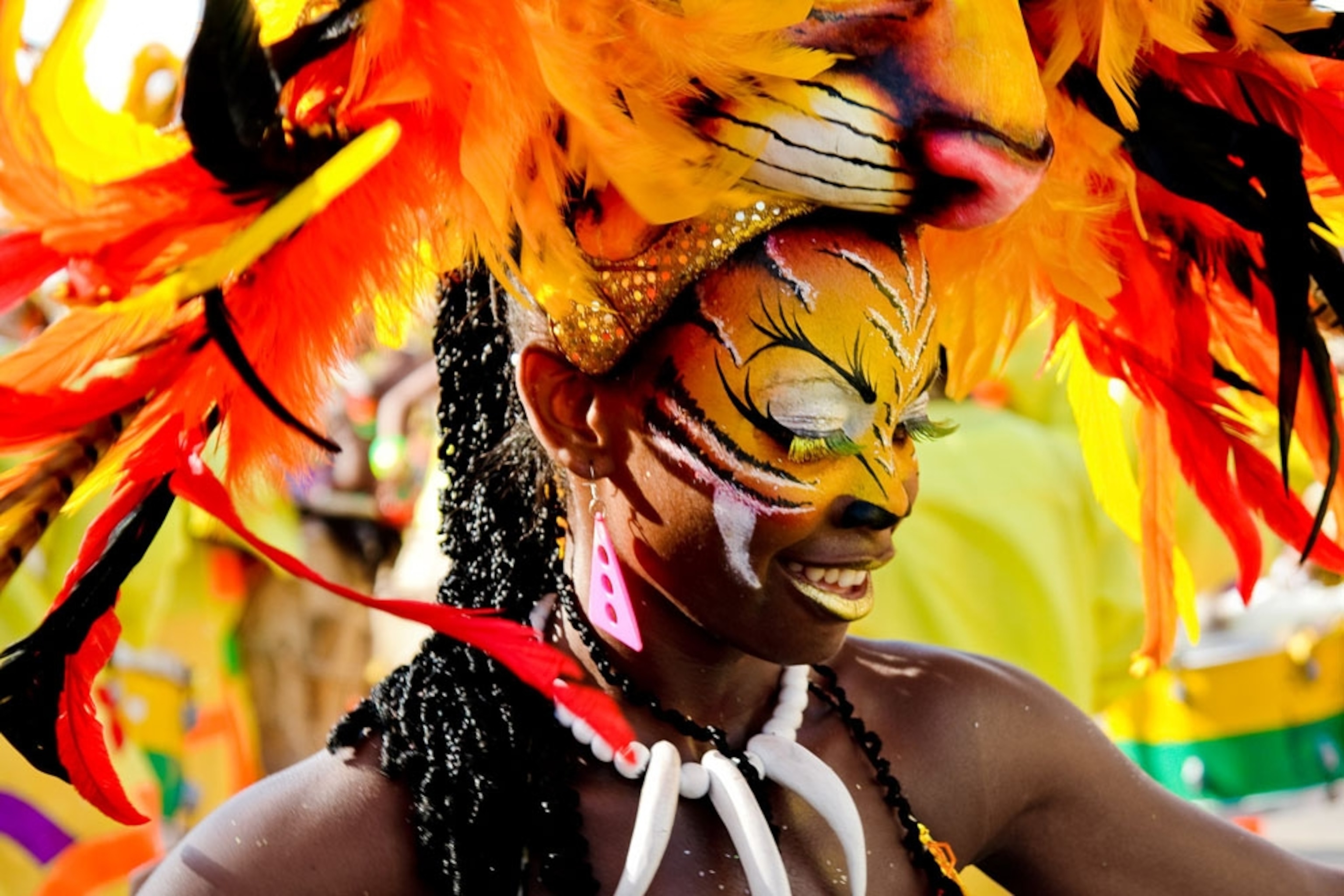 A woman in a colorful feathered headdress and body paint participates in the Carnival of Barranquilla on the Caribbean coast of Colombia