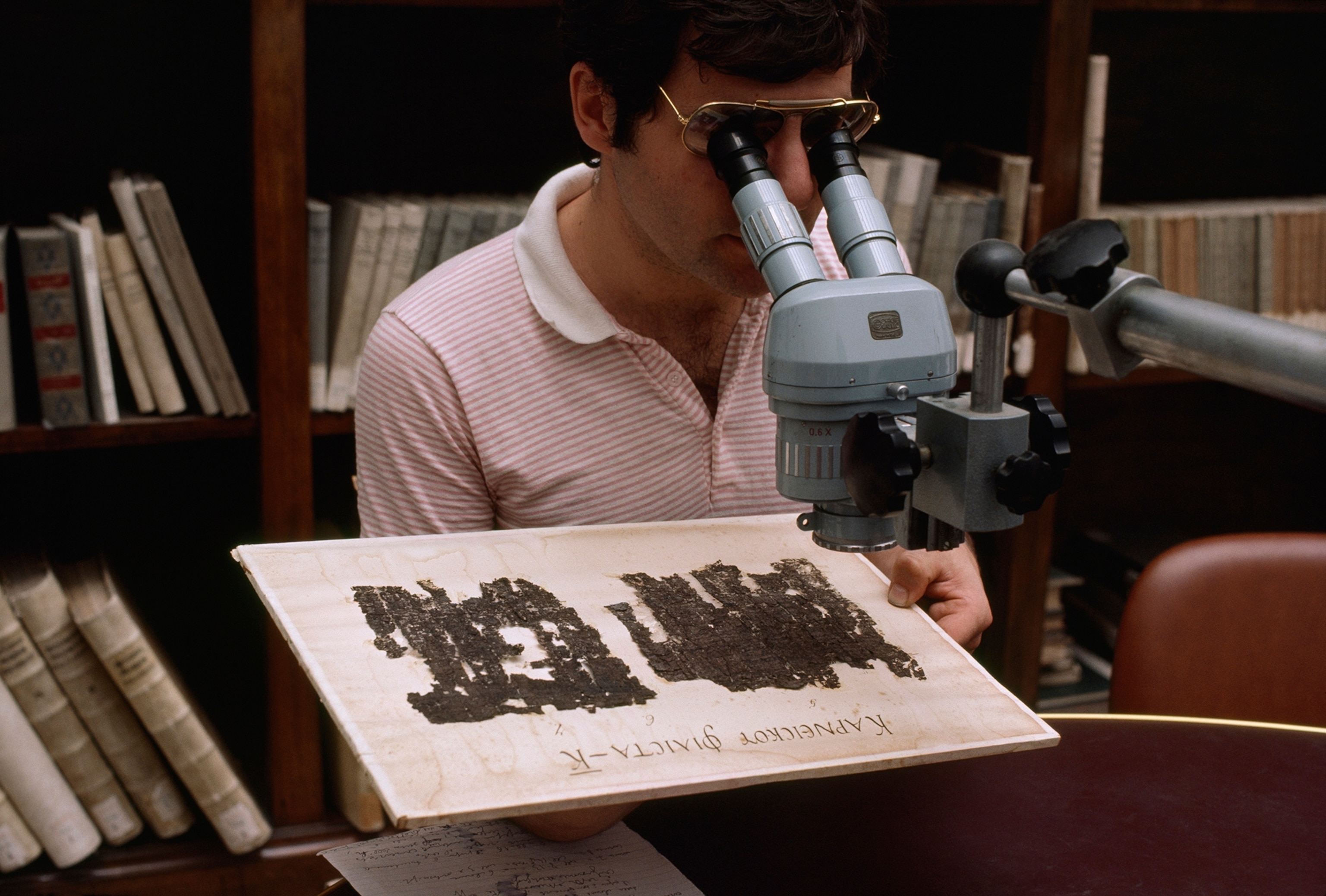A scholar studies a scroll recovered from first-century A.D. estate.