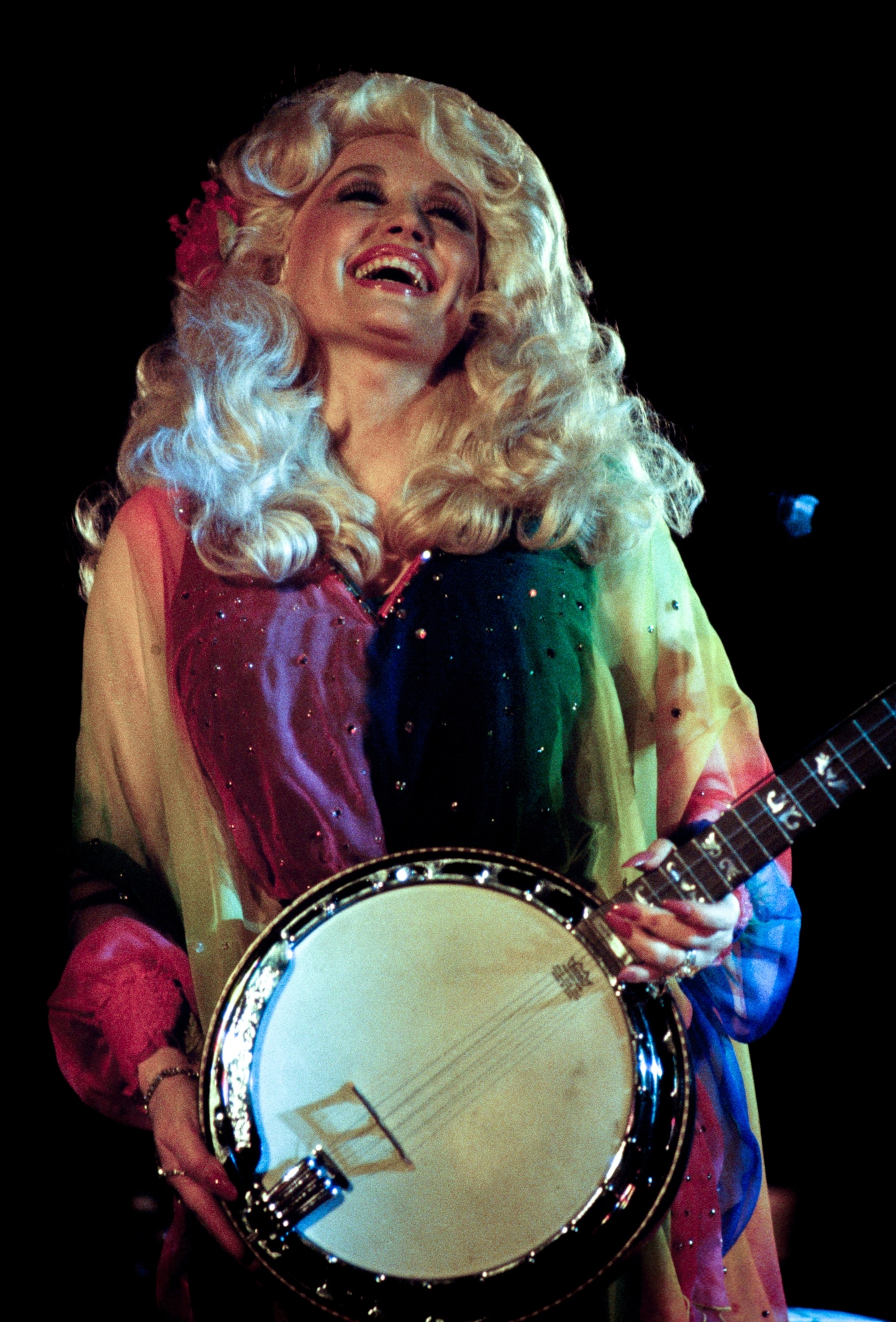 Dolly Parton entertains with country music played on a banjo.