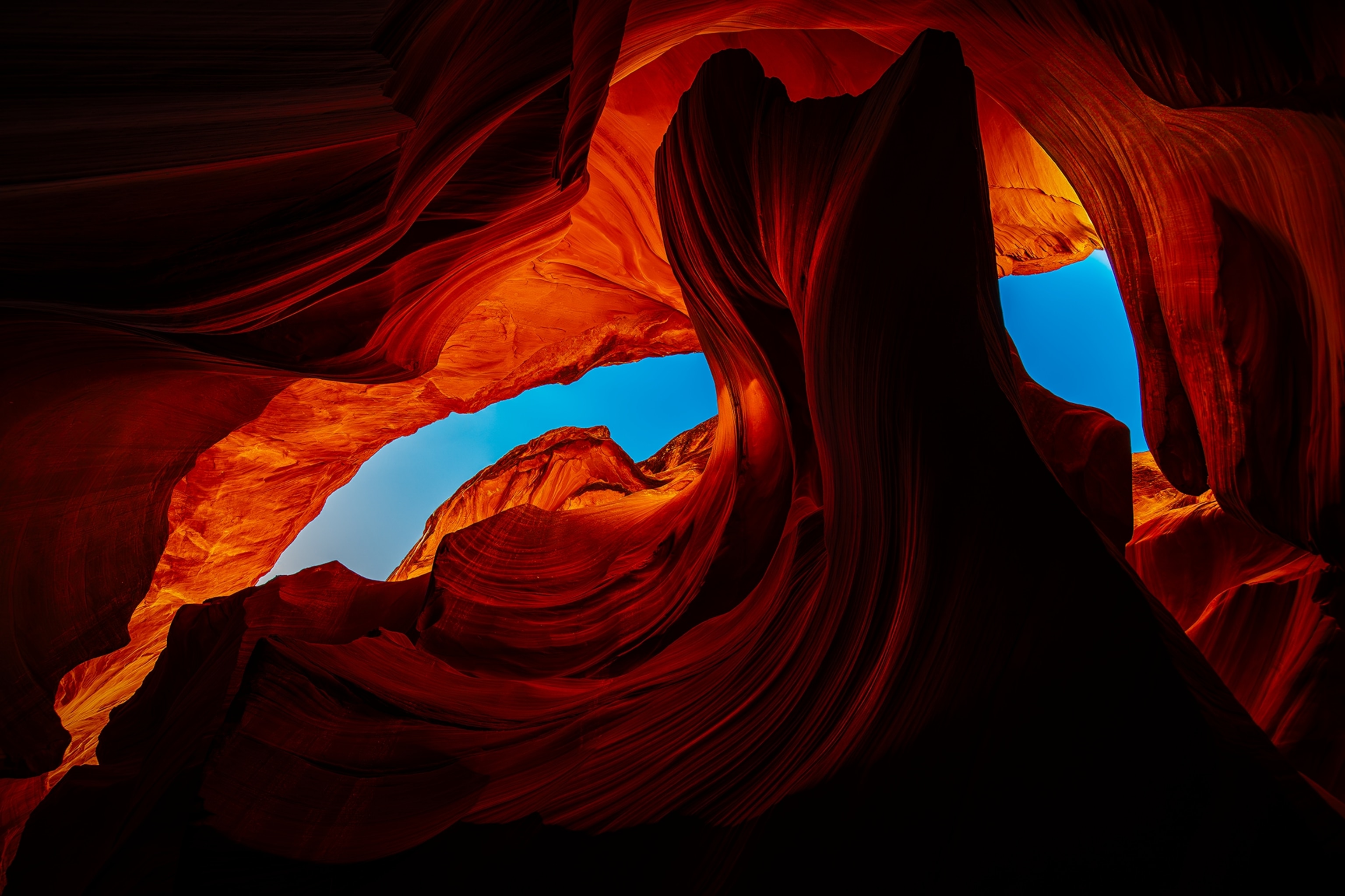 The curves and swirls of a Canyon opening shot from below against a blue sky.