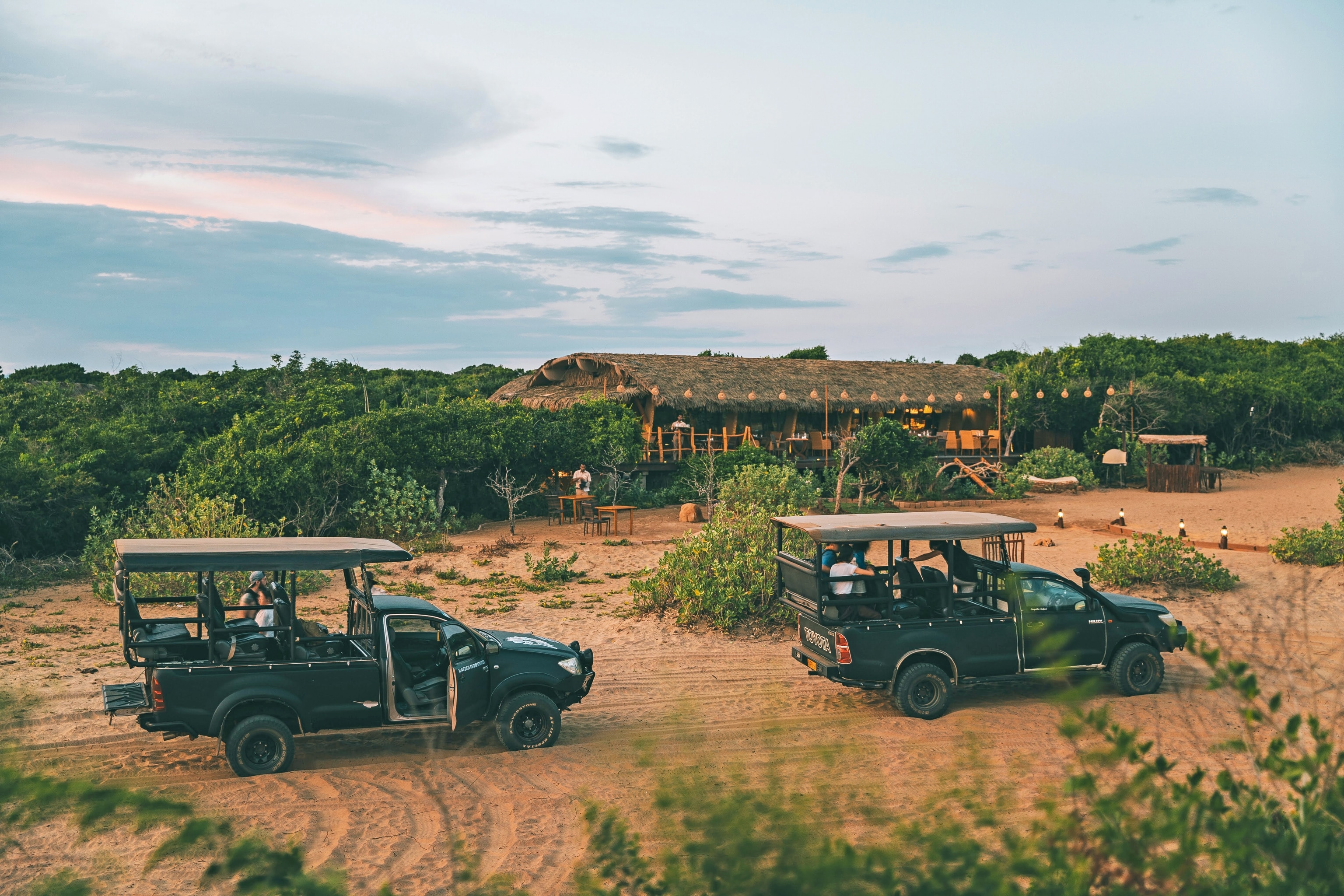 Safari truck driving past wooden building