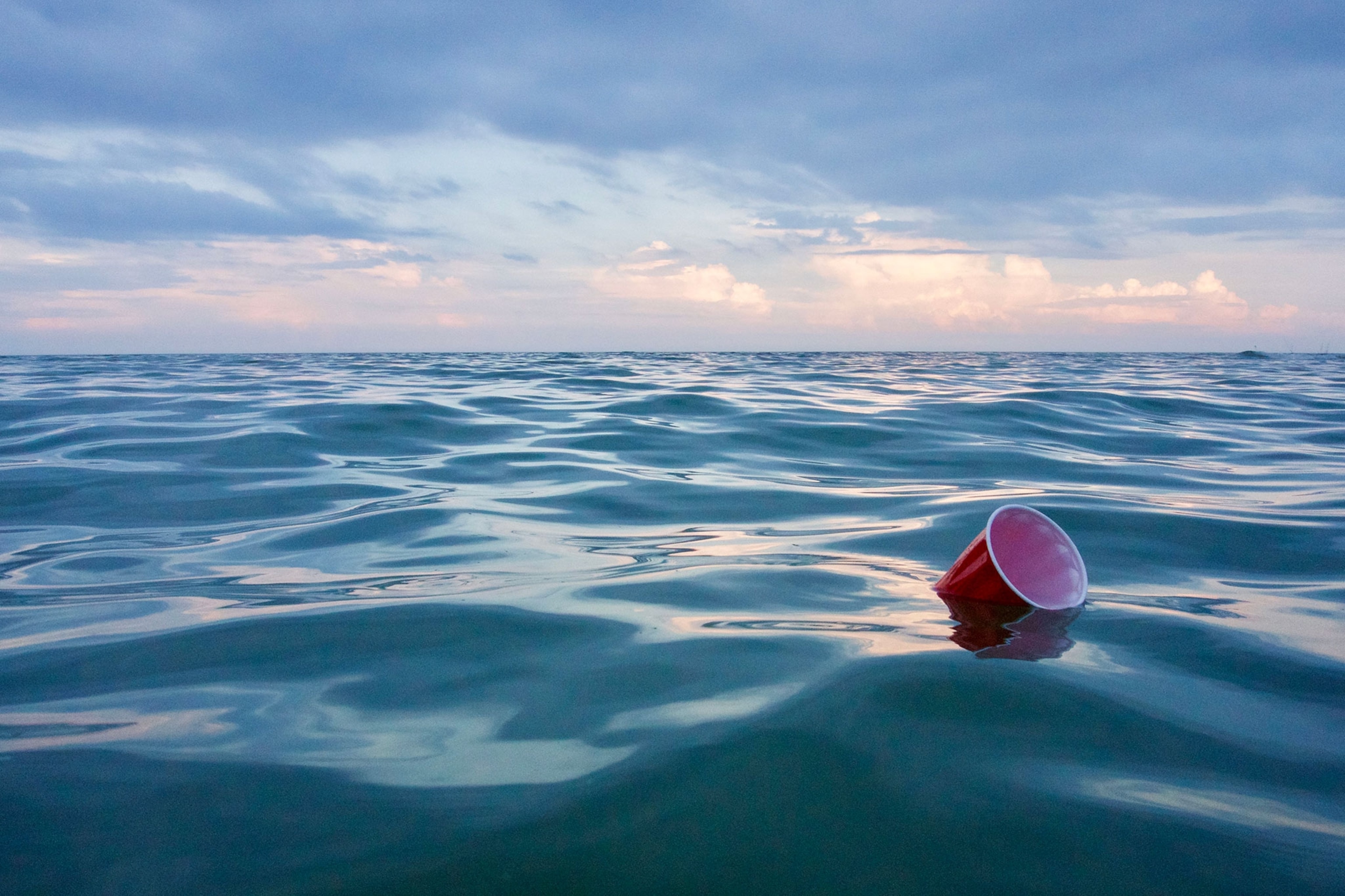 a red cup floating in the lake