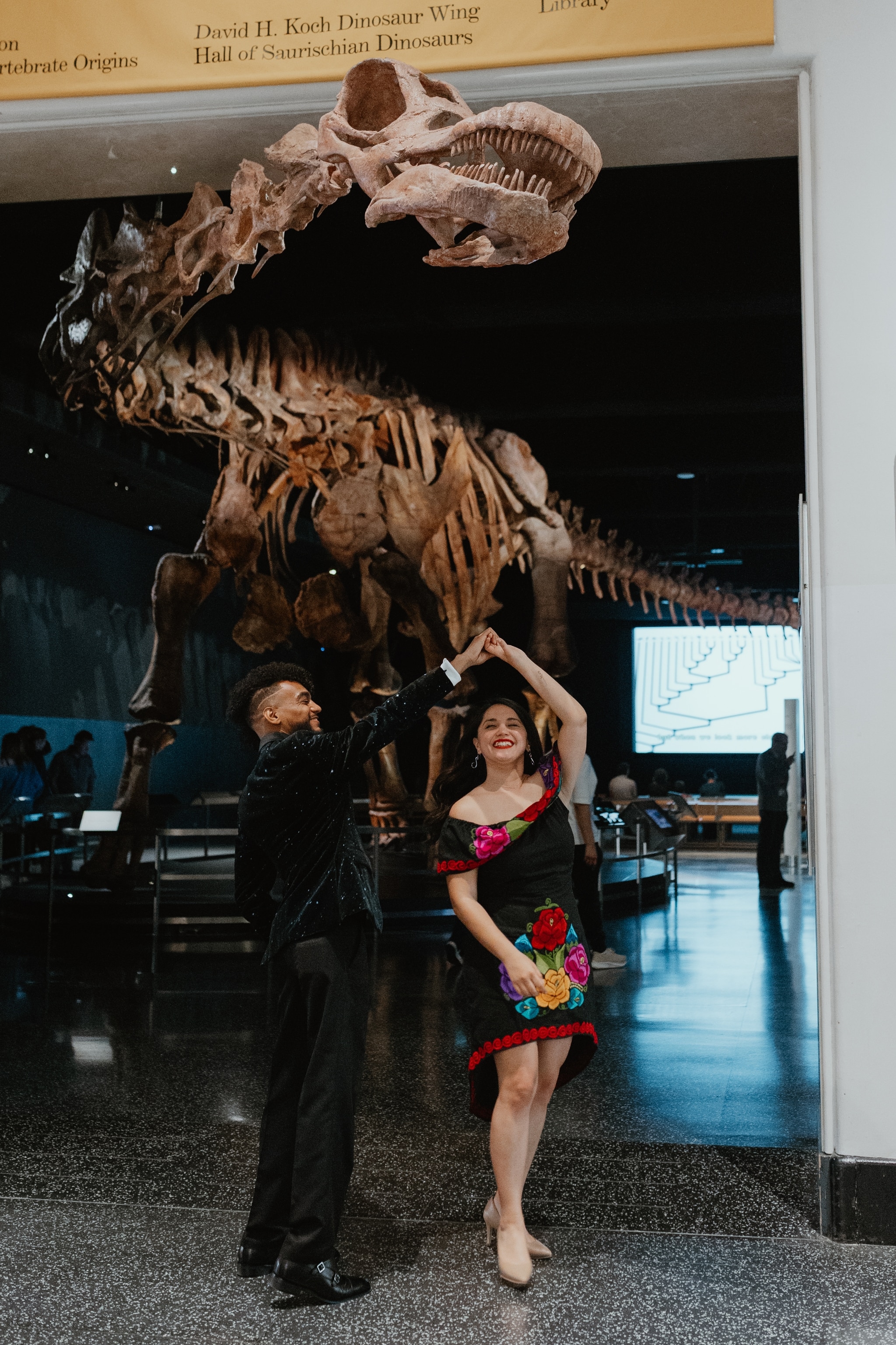 Science editor Nicholas St. Fleur and wife Miranda St. Fleur beneath the Patagotitan at the American Museum of Natural History