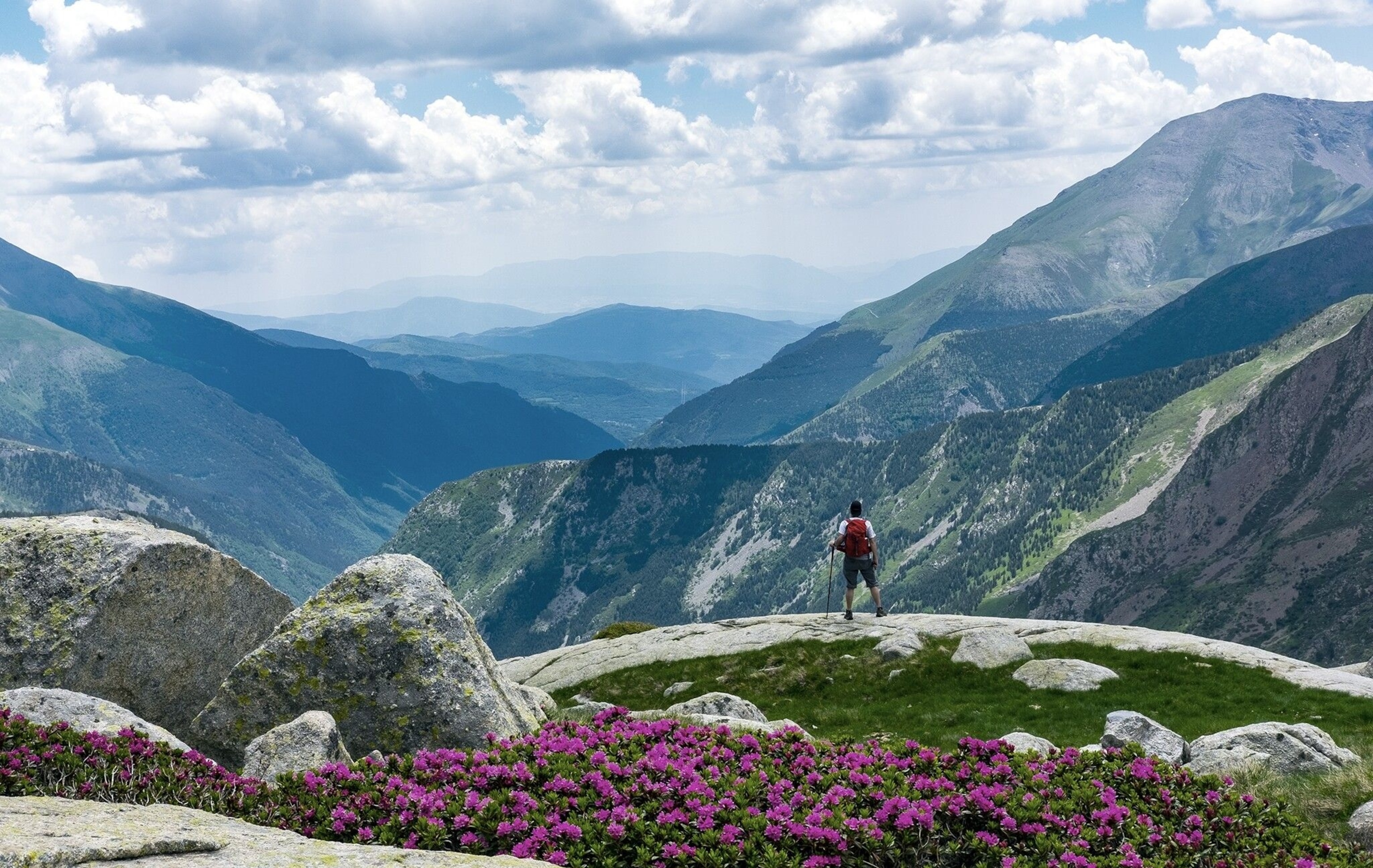 A hikers looks out at the mountainous landscape of Catalonia's Aigüestortes i Estany de Sant Maurici National Park.
