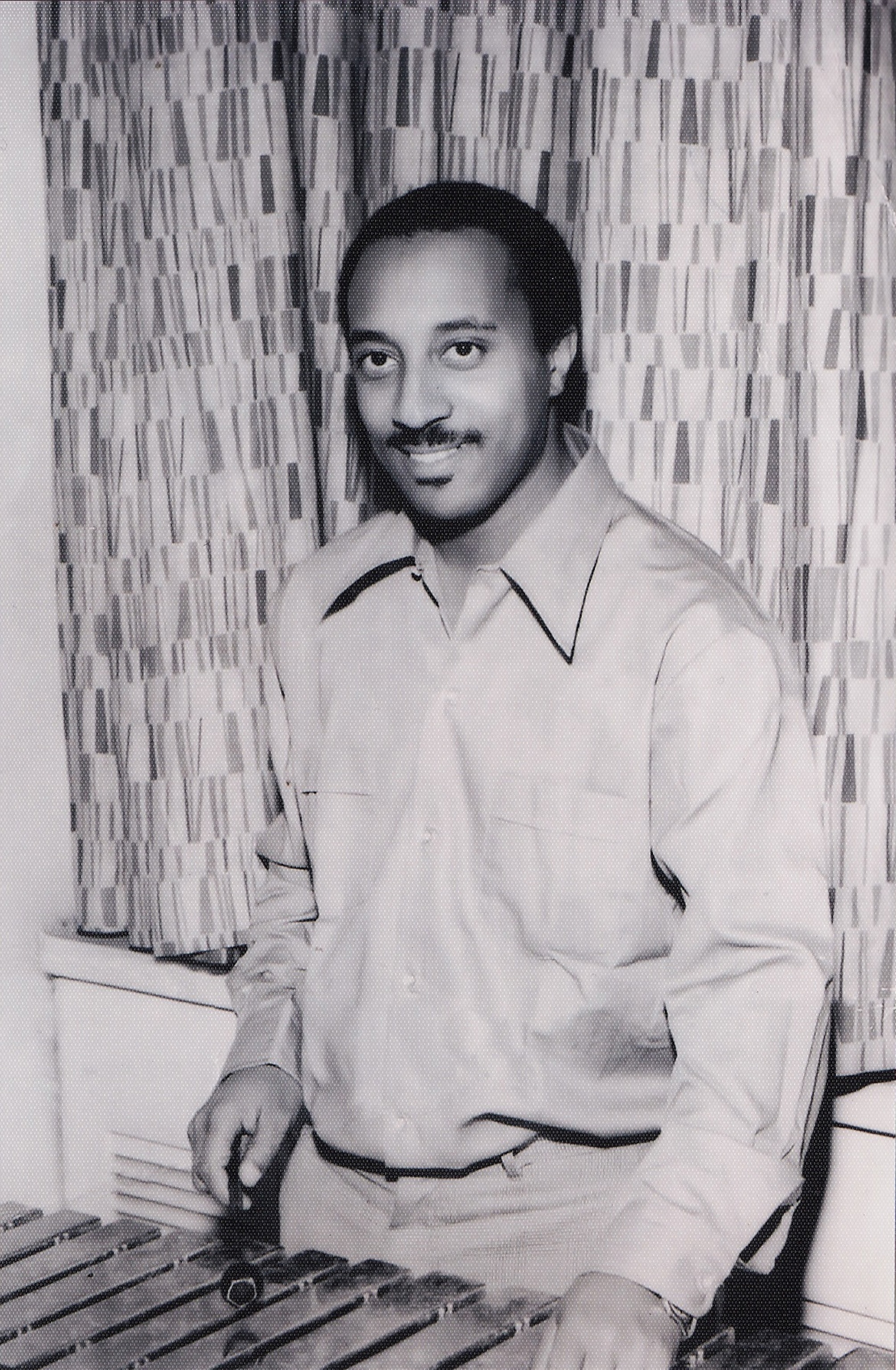 A black and white photograph of a man playing an xylophone.