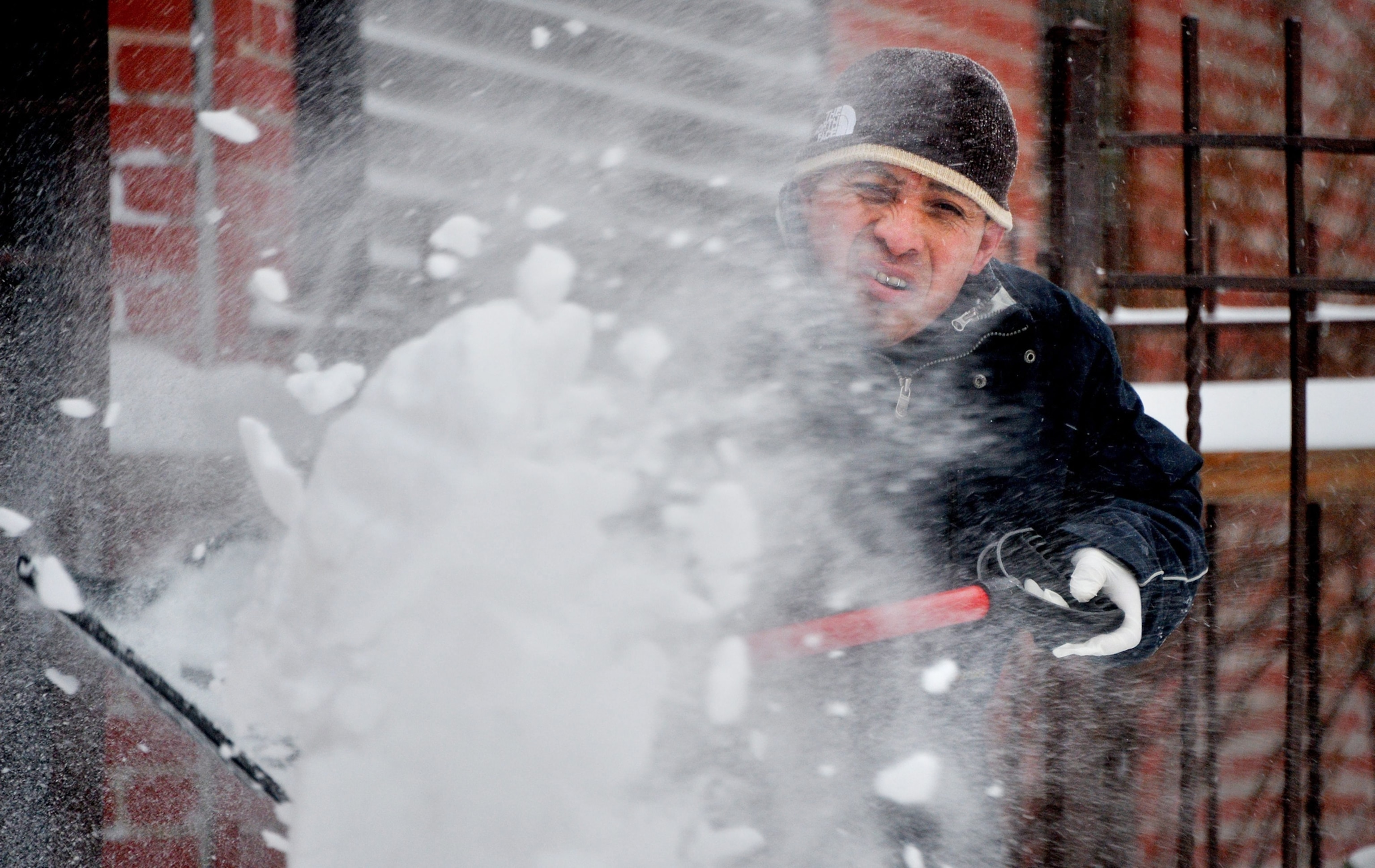a man shoveling snow in Brooklyn, New York, on Friday