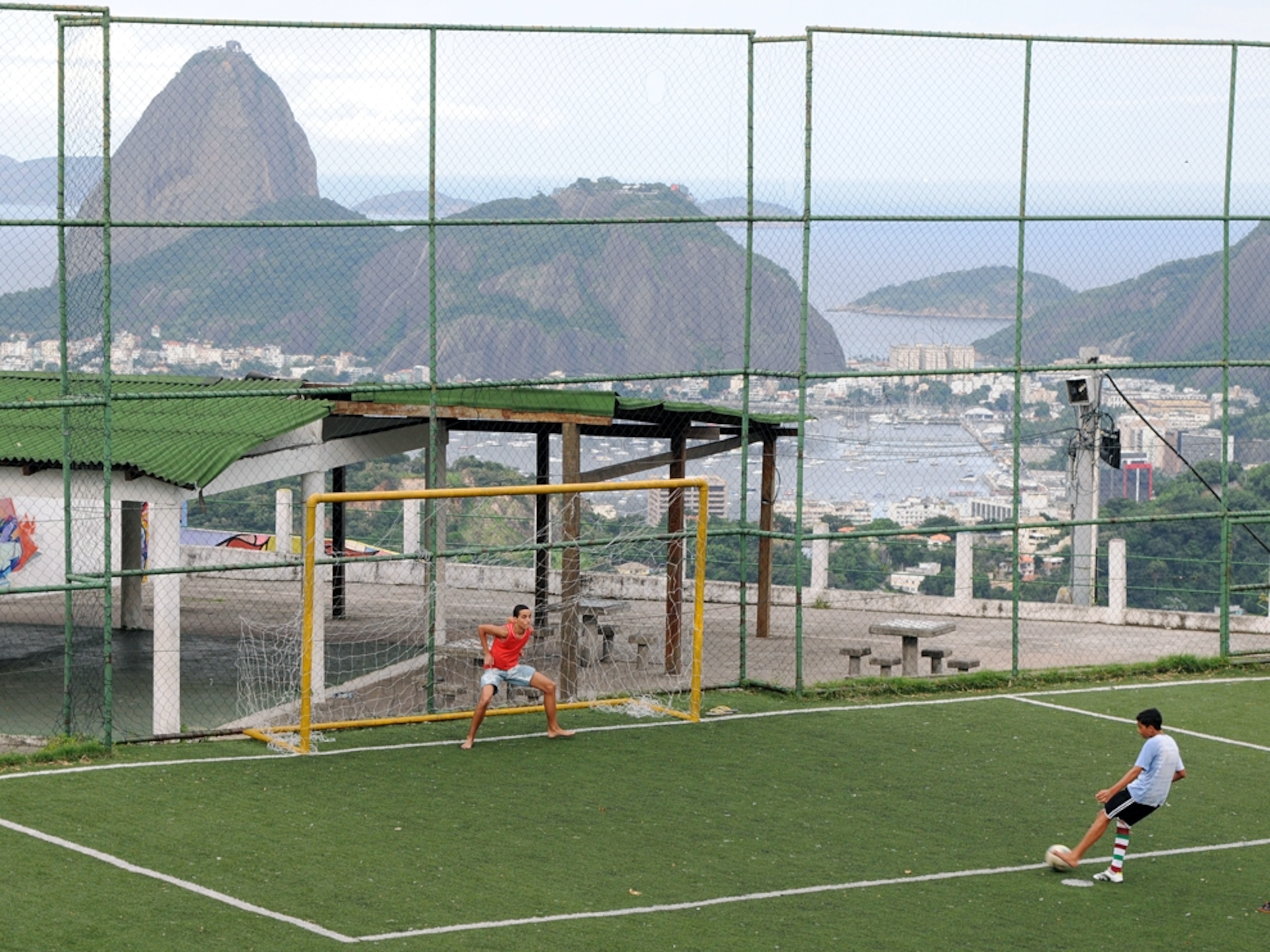 two boys playing soccer above the Pao de Azucar and the Bay de Guanabara