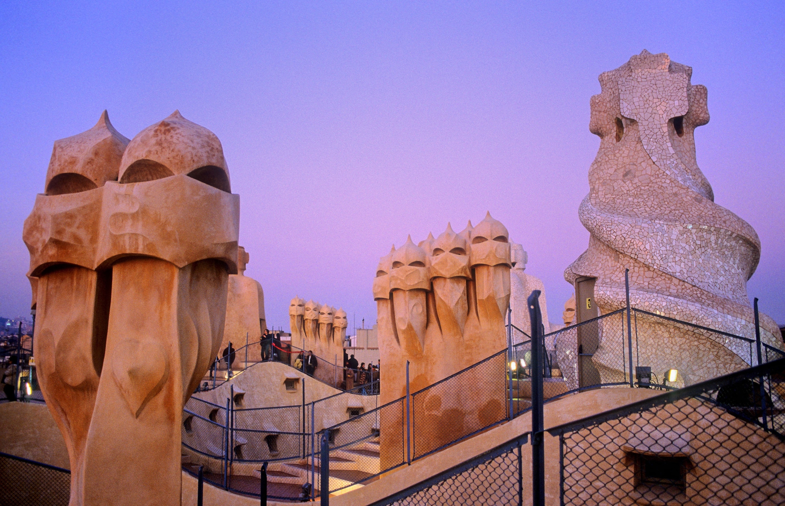 Light tan stone chimneys sculpted to resemble medieval knights at dusk.