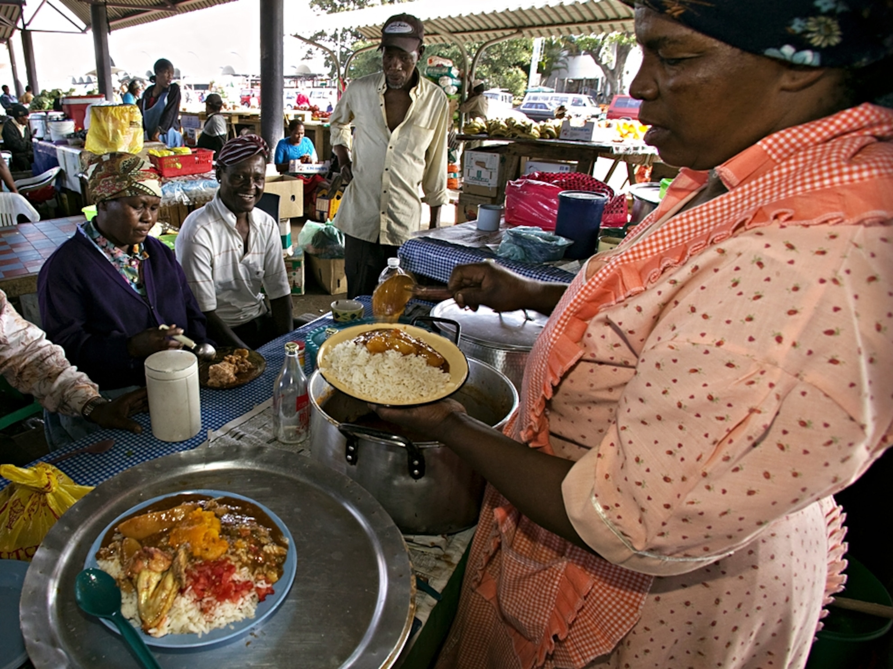 A woman serving food to customers in Durban