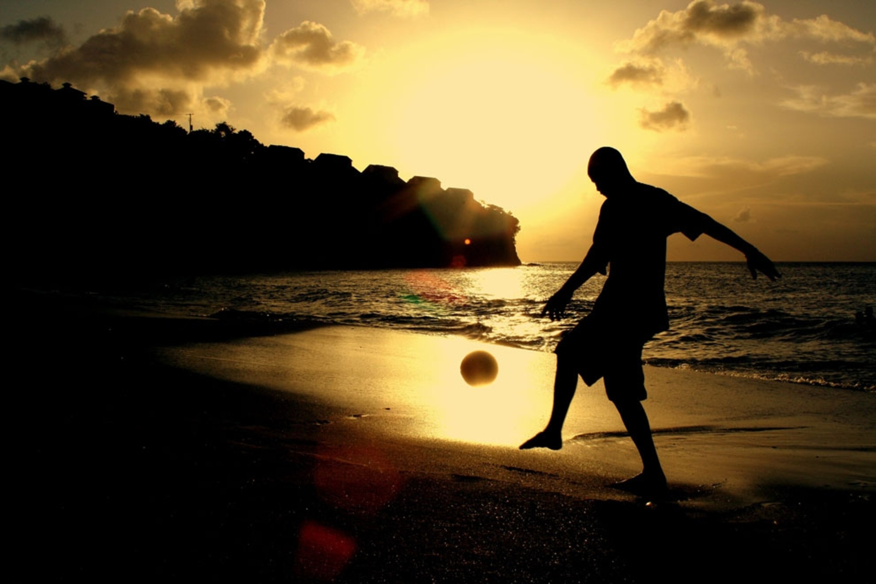 A local man practices his football skills on the beach of St. Lucia