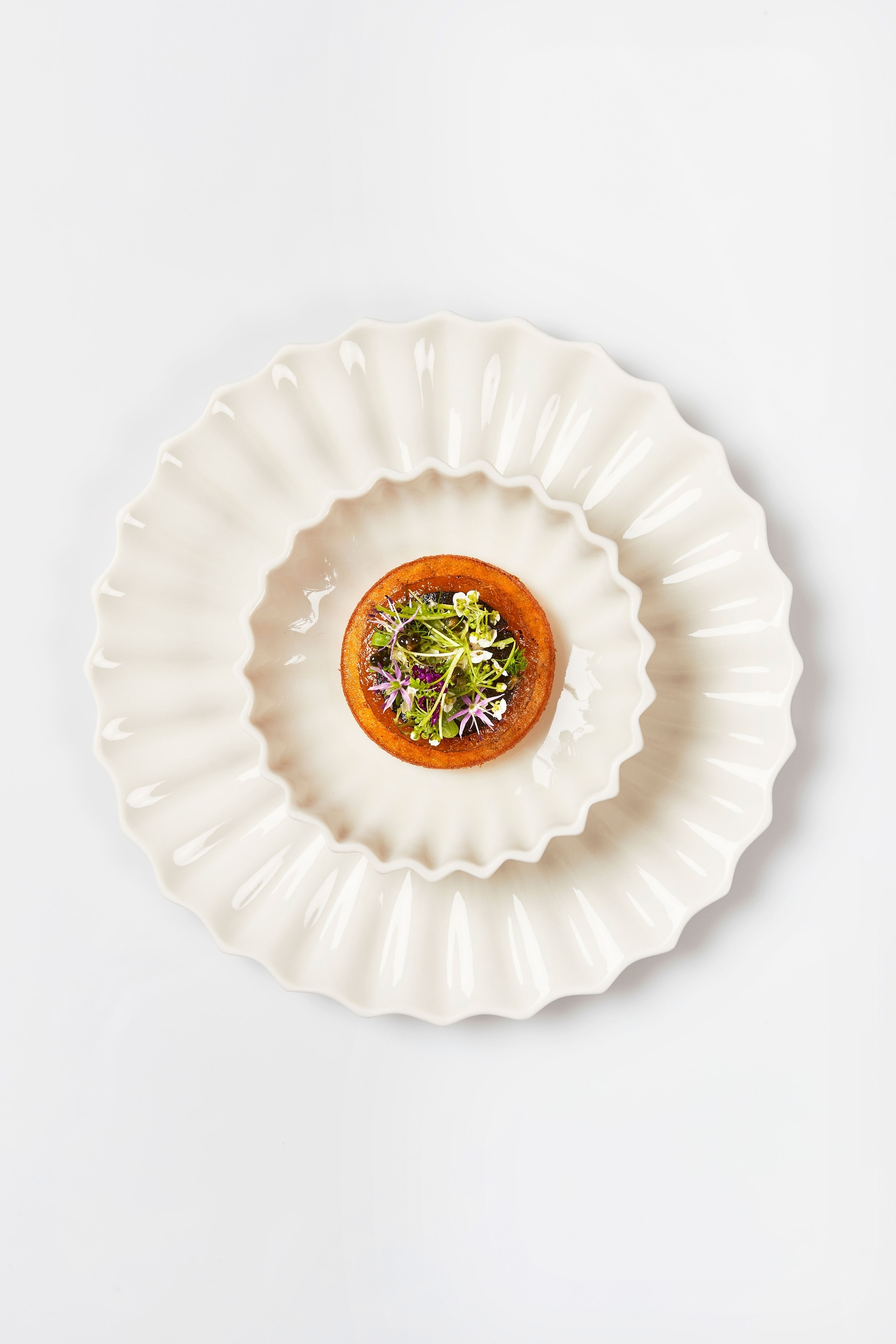 pancake served atop two shell-themed cream dishes