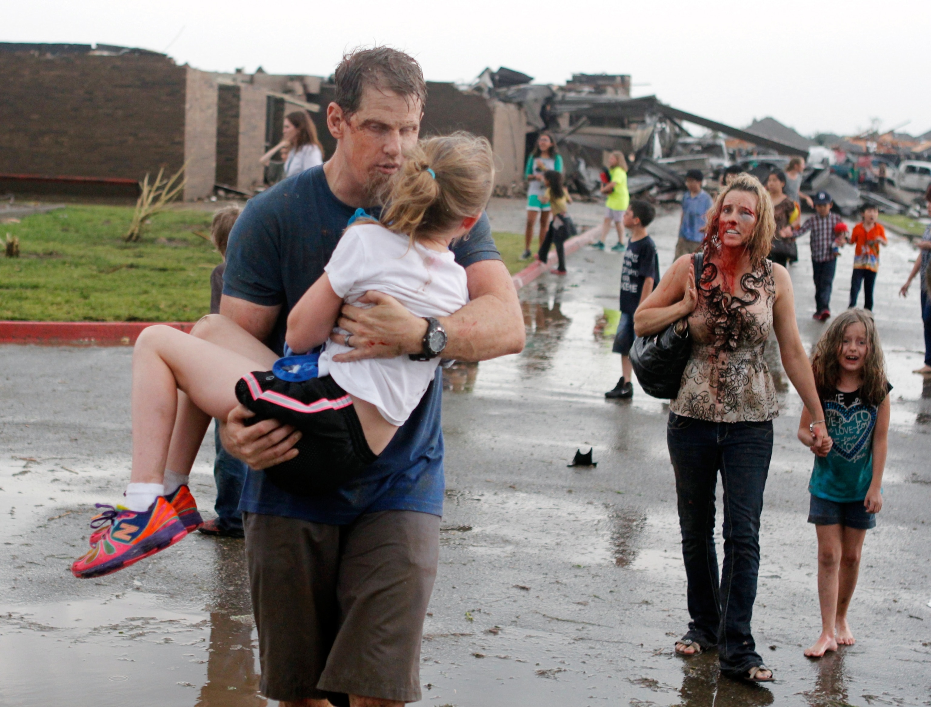 Teachers carry children away from the destroyed elementary school.