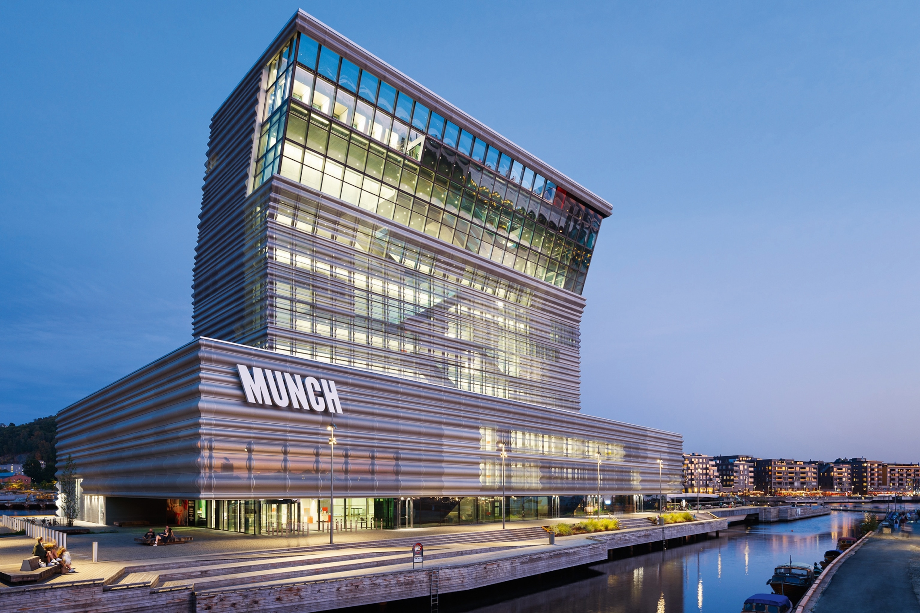A modern seafront building with 'Munch' in lettering on one corner.