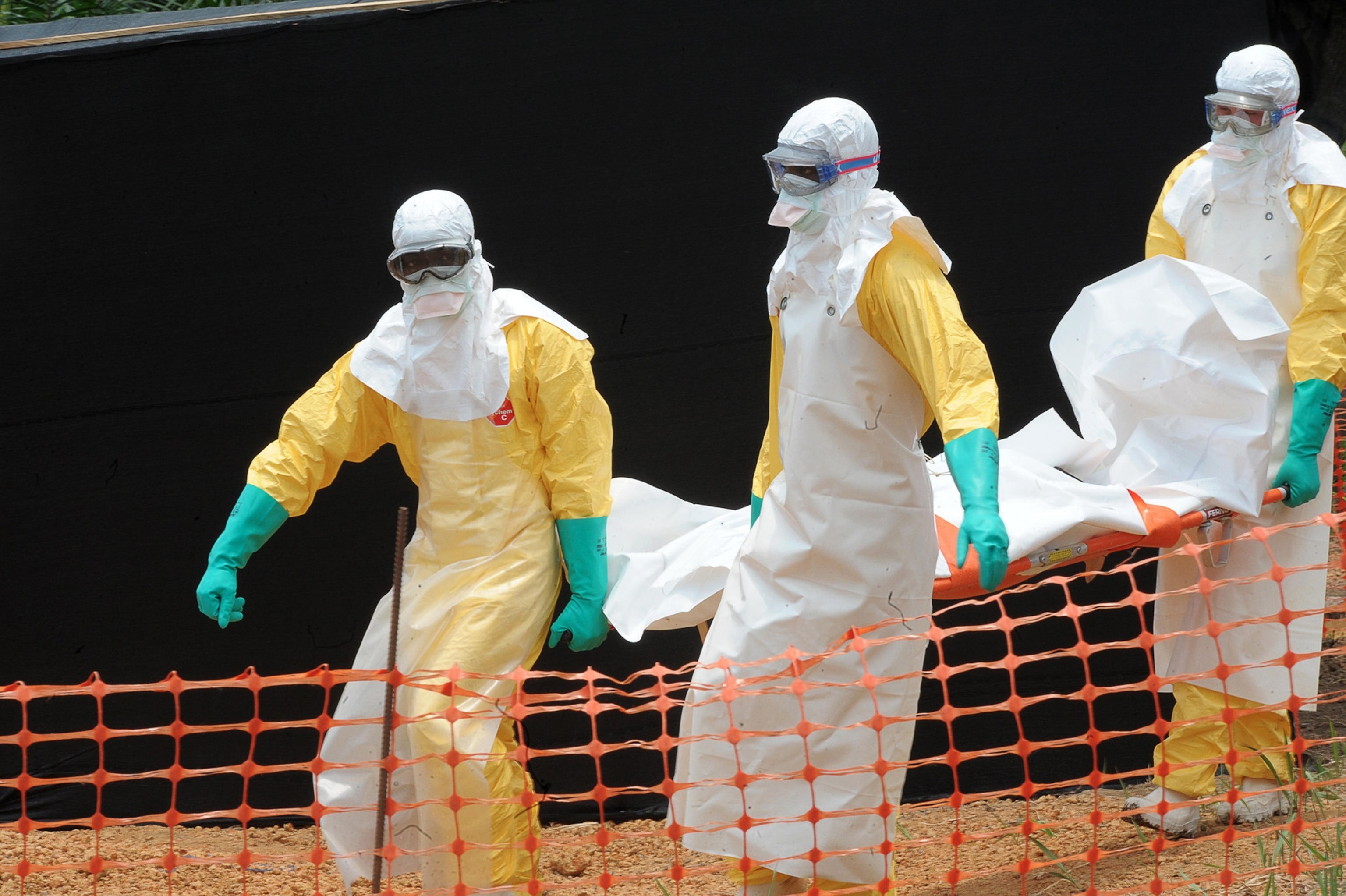 Staff of the 'Doctors without Borders' ('Medecin sans frontieres') medical aid organisation carry the body of a person killed by viral haemorrhagic fever, at a center for victims of the Ebola virus in Guekedou, on April 1, 2014. The viral haemorrhagic fever epidemic raging in Guinea is caused by several viruses which have similar symptoms -- the deadliest and most feared of which is Ebola. AFP PHOTO / SEYLLOU (Photo credit should read SEYLLOU/AFP/Getty Images)