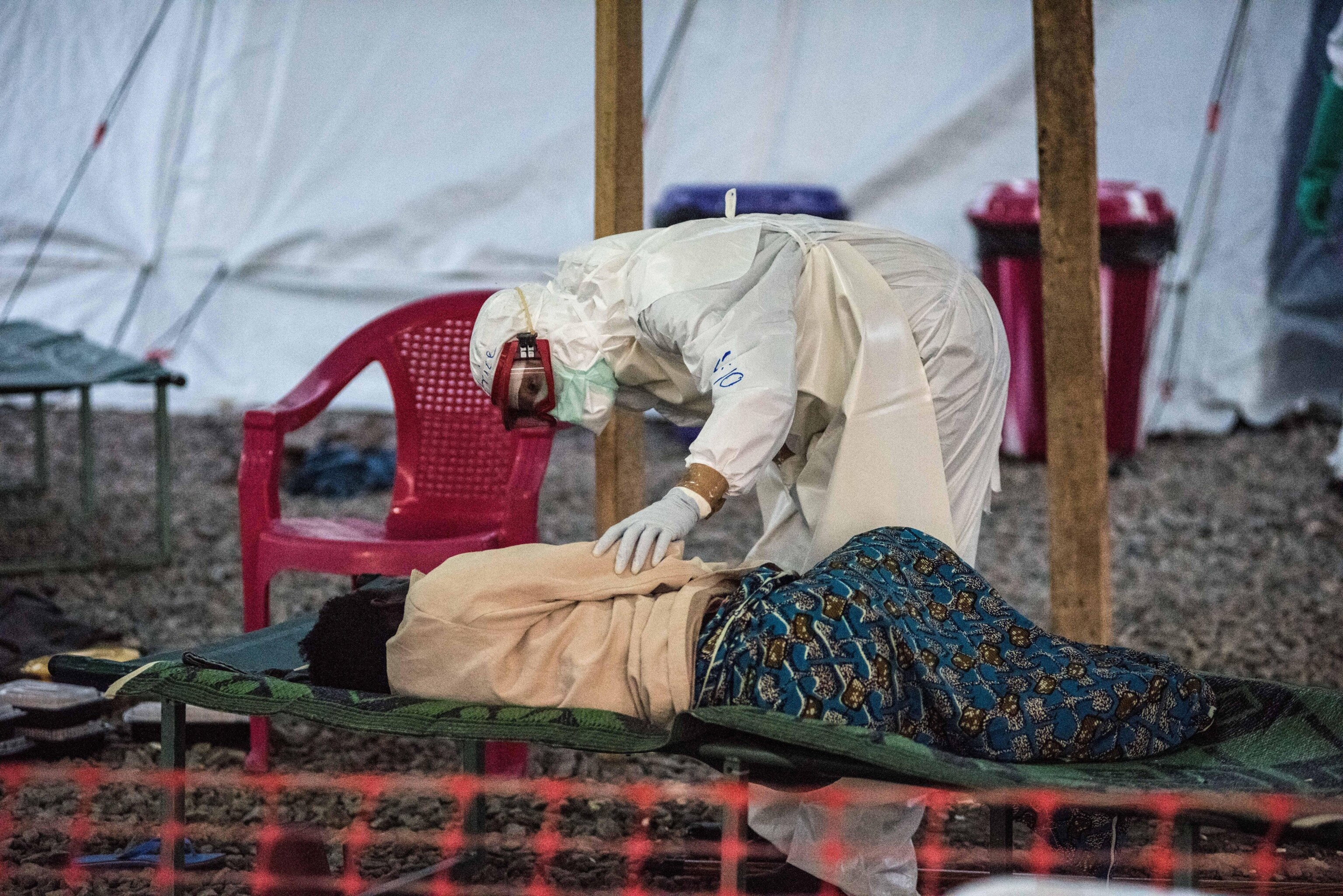 A staff member attends to an Ebola patient in a treatment center.