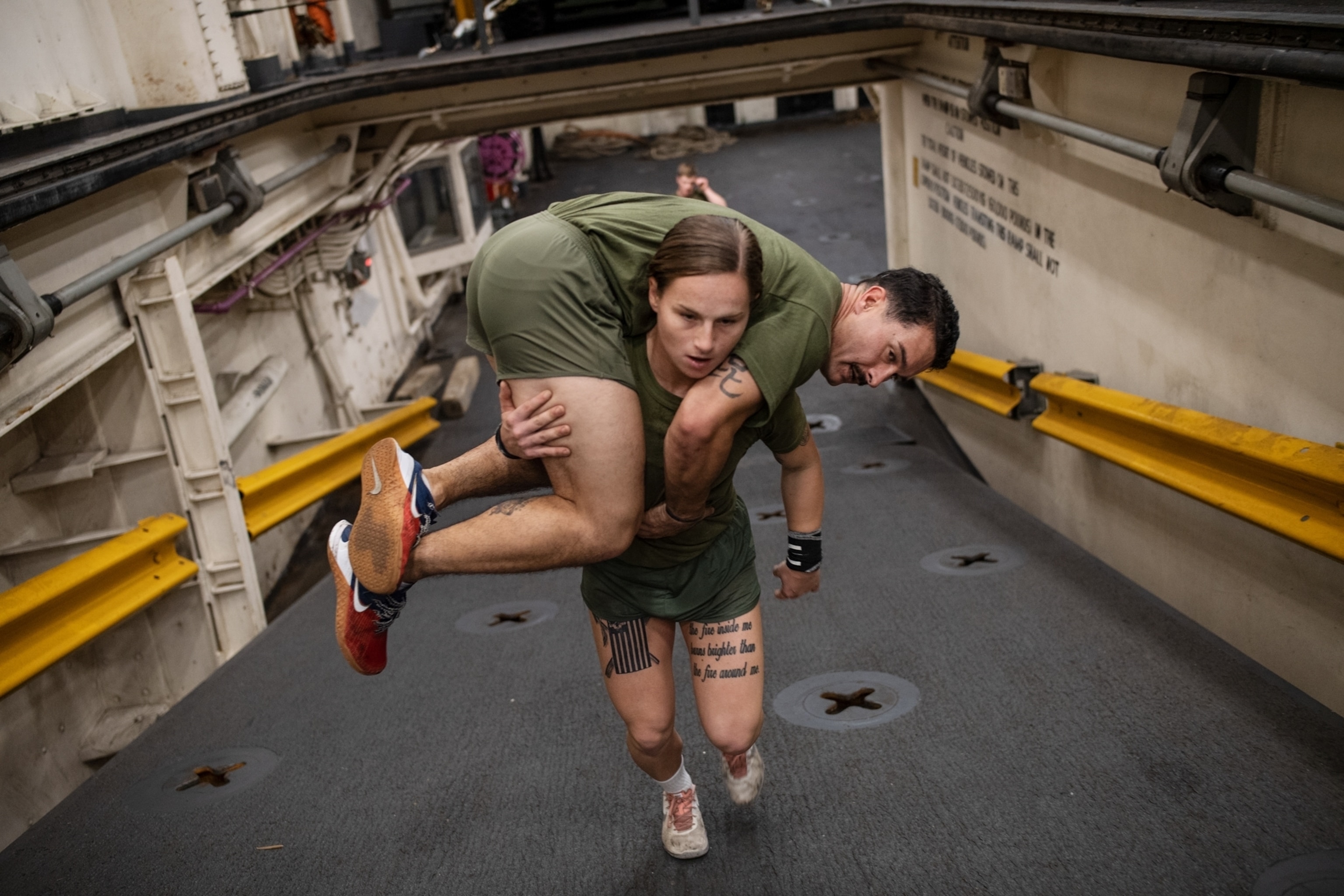 a woman carrying another marine over her shoulders