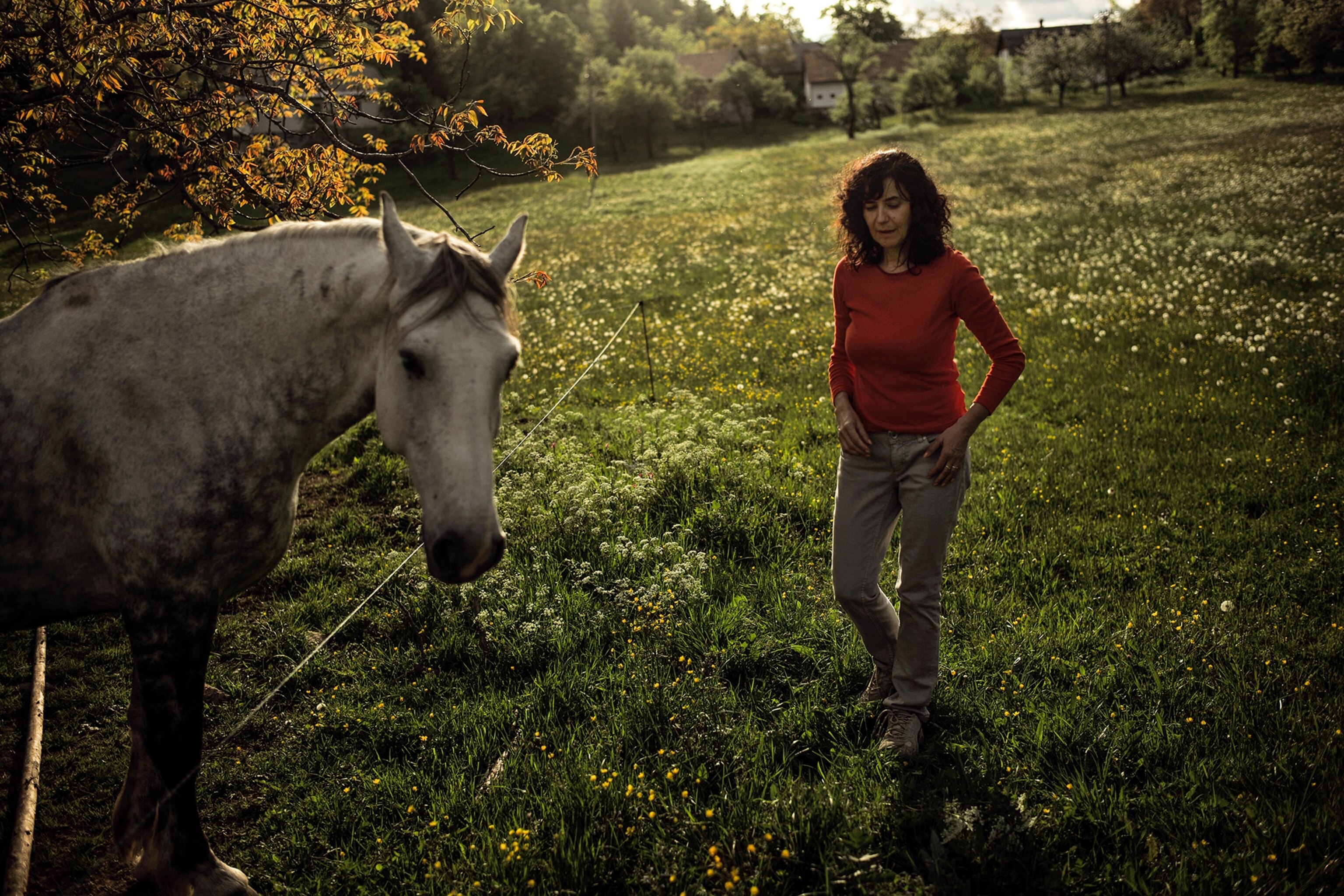 a woman standing with a horse
