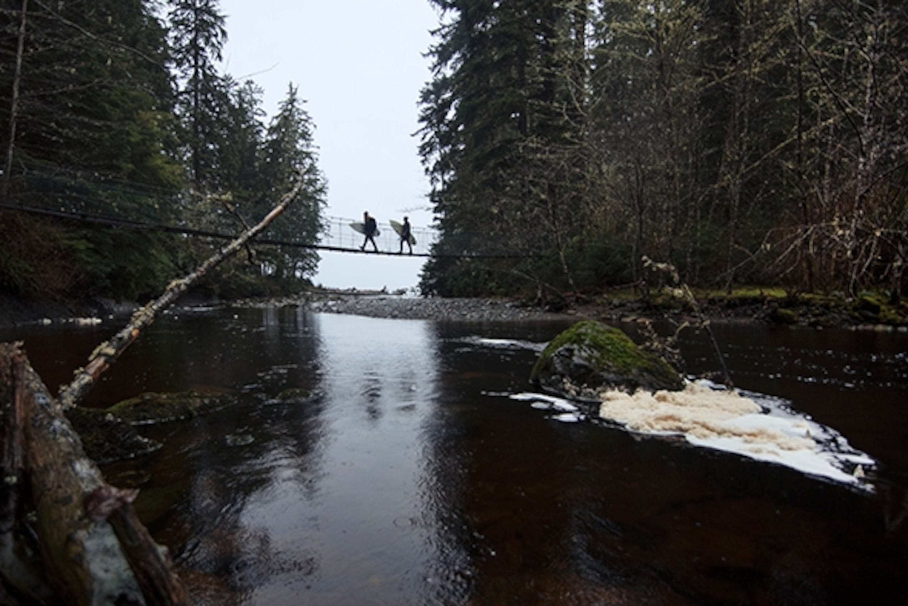 Alex Guiry and Eliel Hindert cross the suspension bridge in sombrio to get to the surf break; Photograph by Max Lowe
