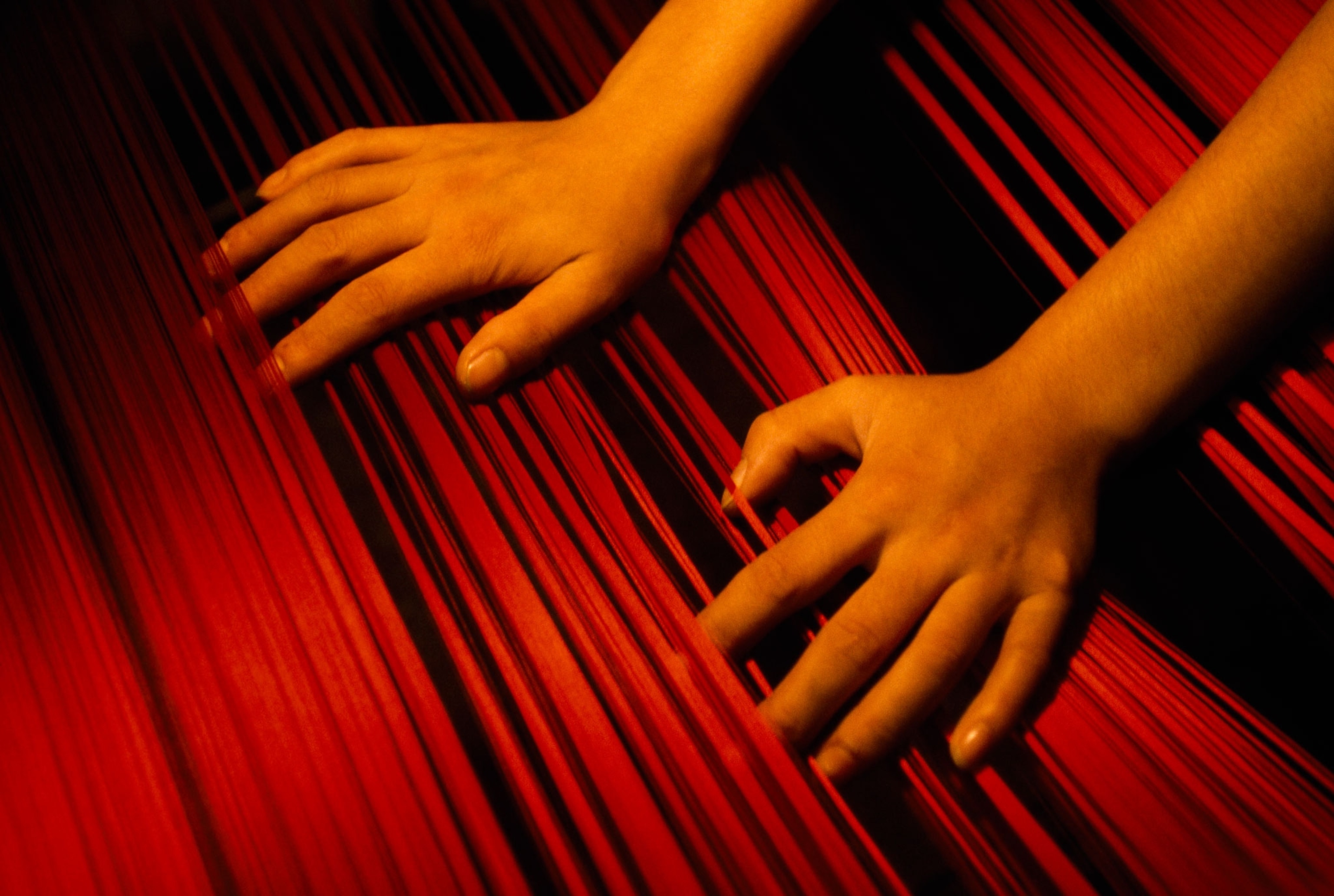 woman's hands on textile loom