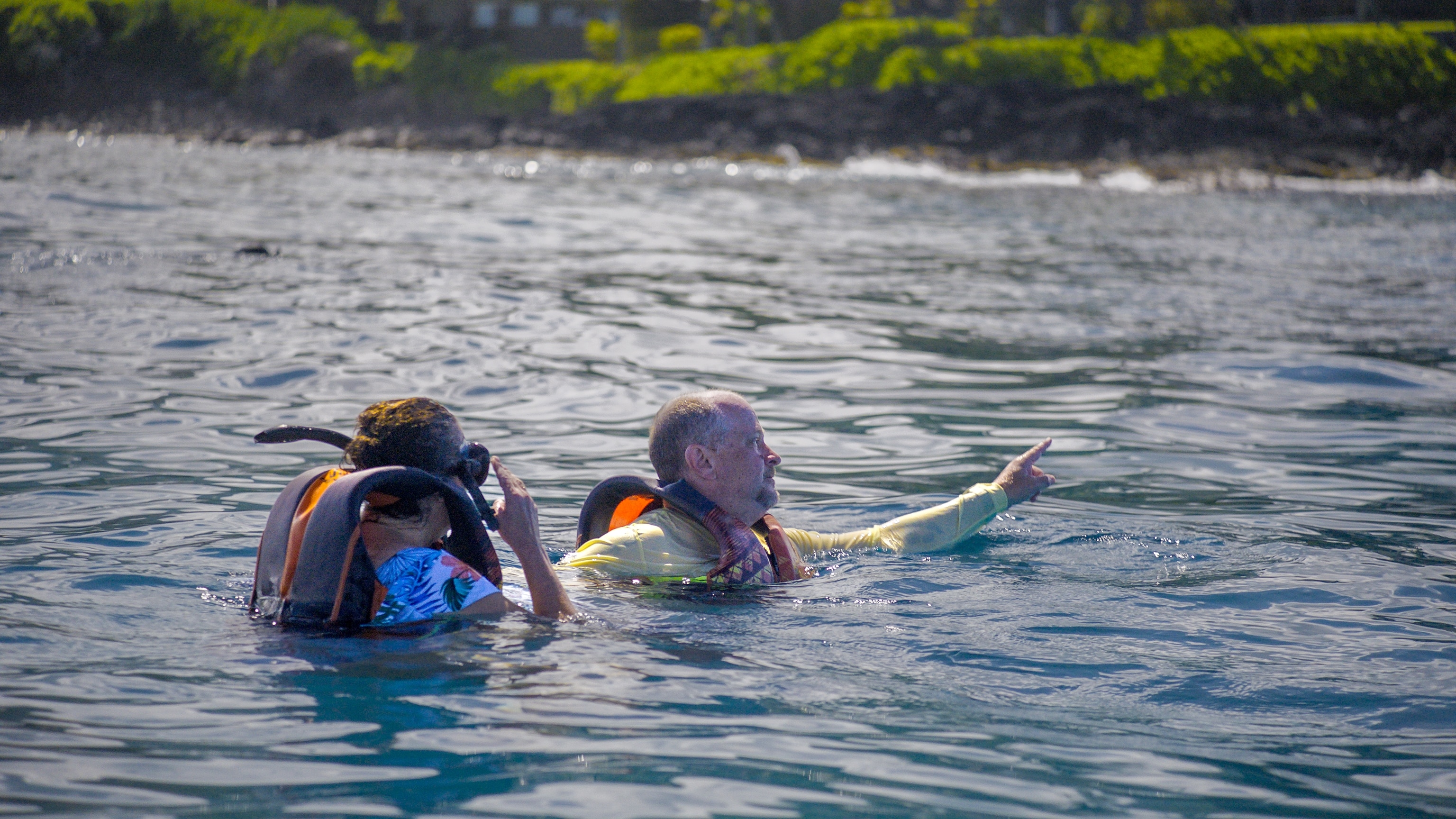 Couple floating in waters of Big Island, Hawaii