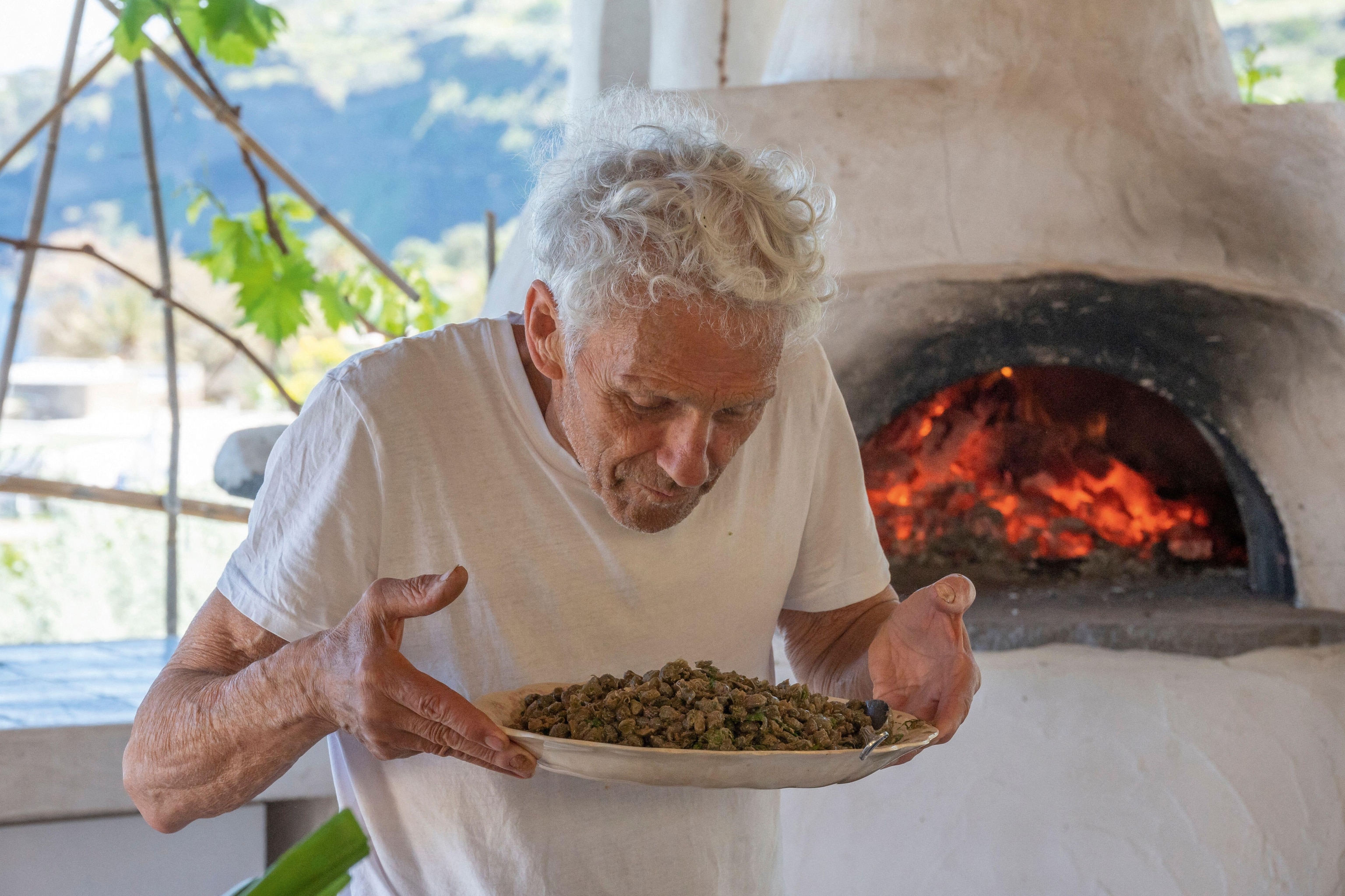 Man holding caper salad in a kitchen