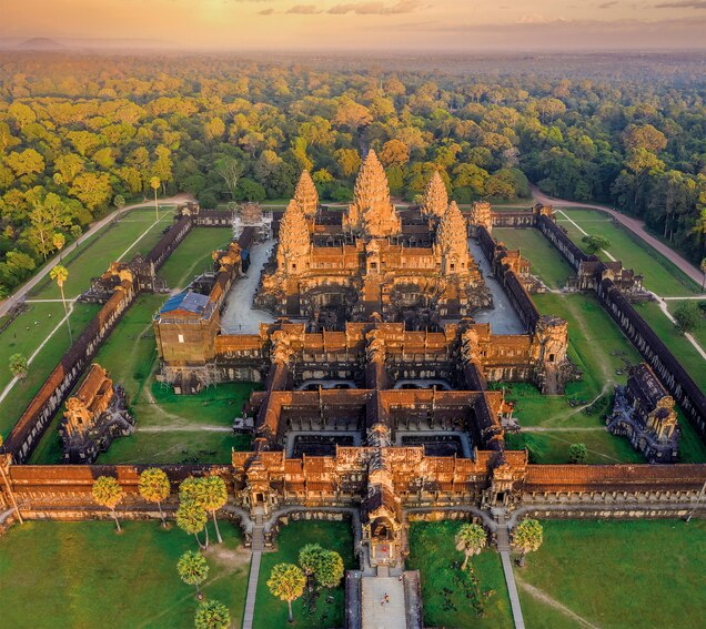 An aerial view of Angkor Wat offers a fresh perspective on the 900-year-old complex, showcasing its intricate shapes and sheer magnitude. A wall nearly 15 feet high surrounds the temple, with an entrance at each cardinal point.