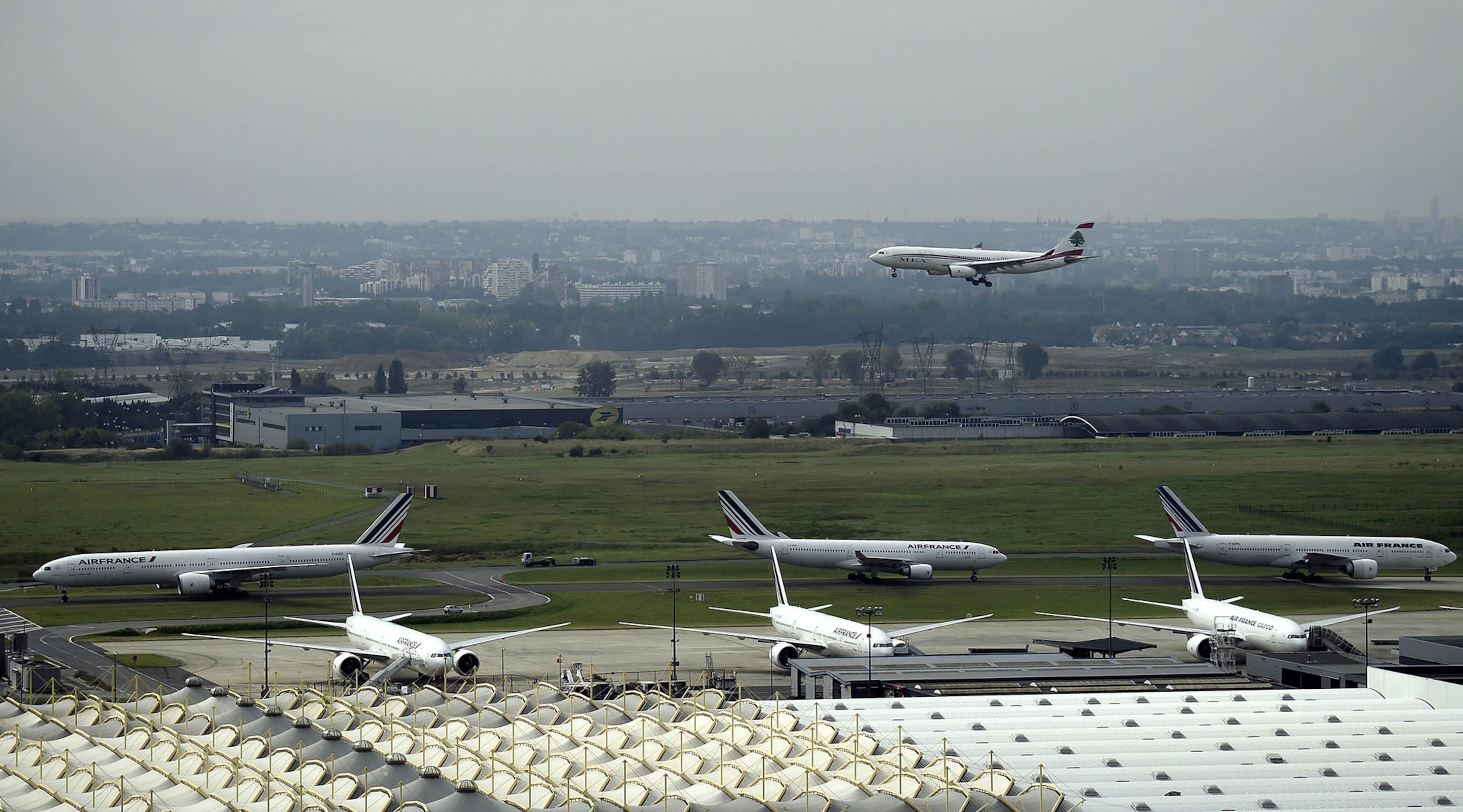 aircraft takes off as Air France planes sit on the tarmac at Paris-Charles de Gaulle airport.