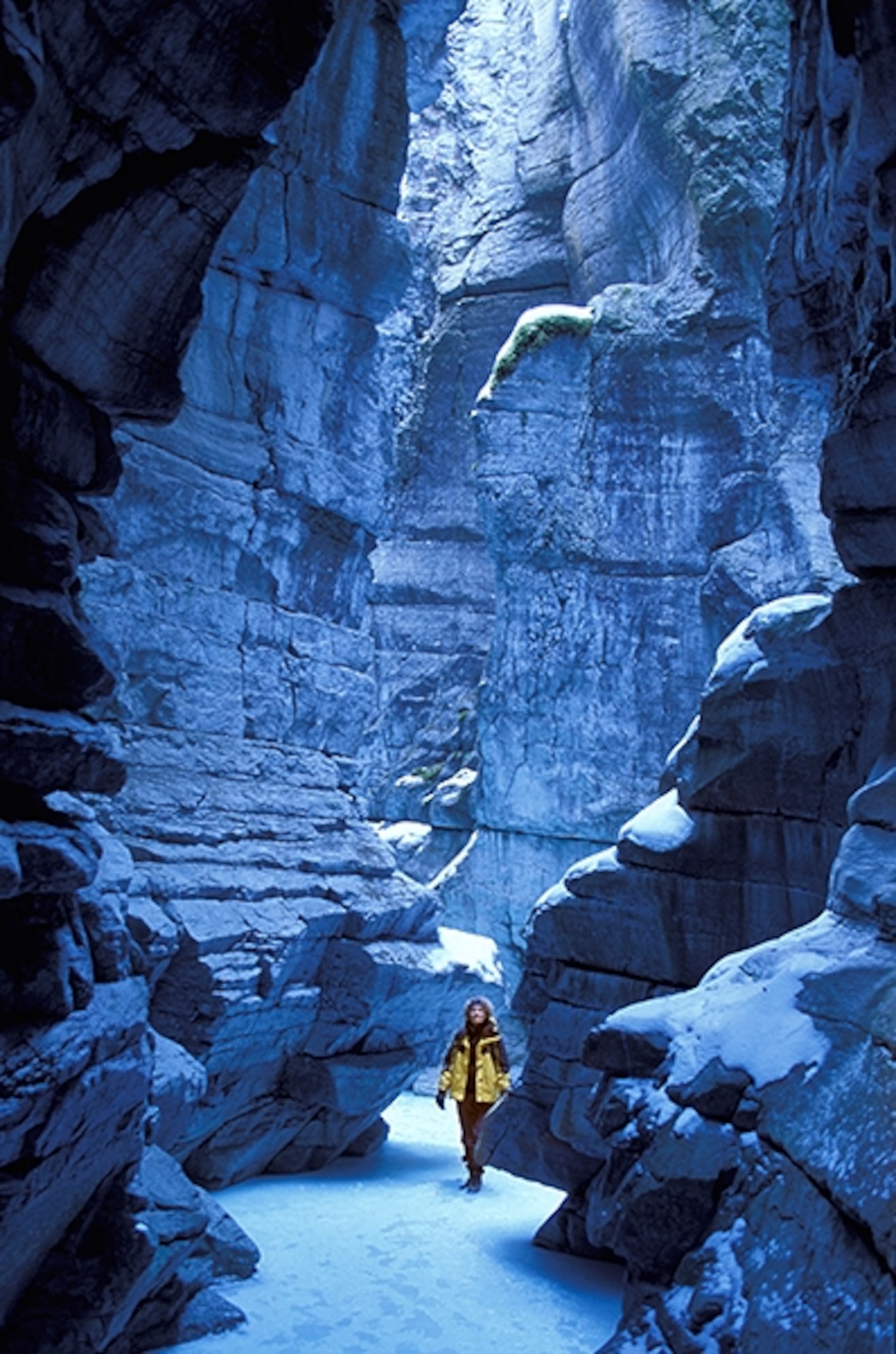 a woman walking on ice in Maligne Canyon, Jasper National Park