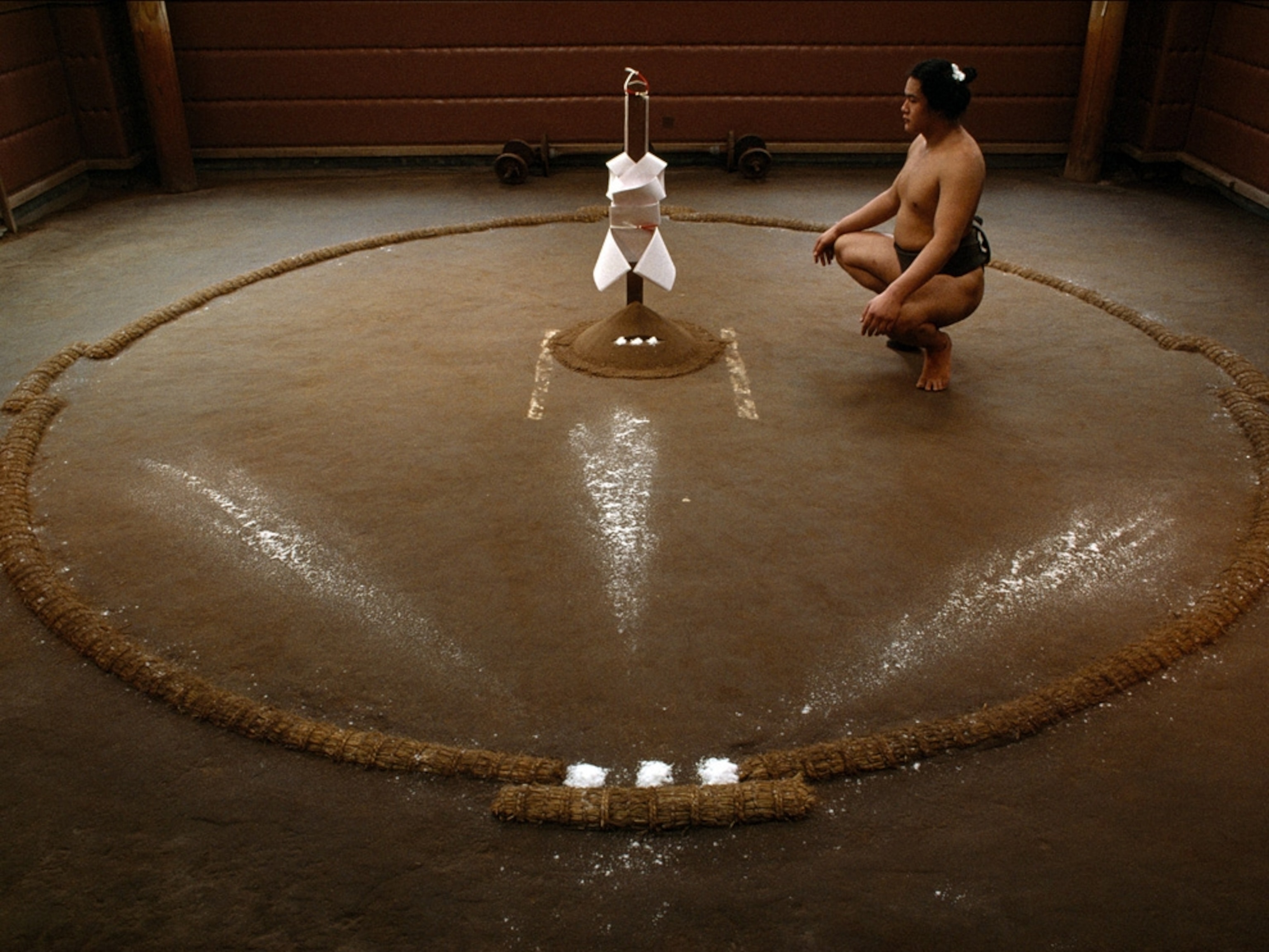 Sumo wrestler meditating before shrine
