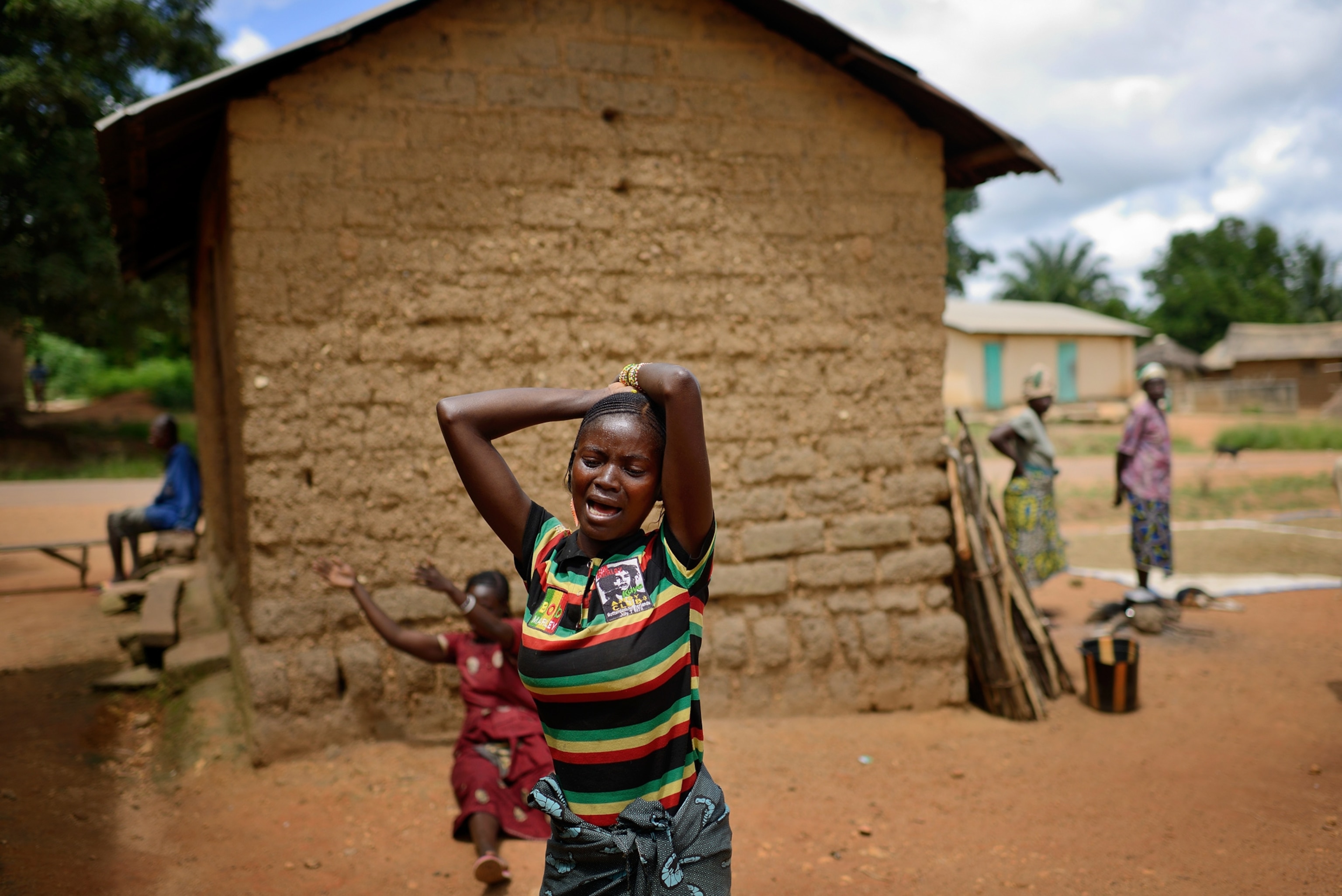 Locals watch workers with Doctors Without Borders as they disinfect after leaving a private clinic.
