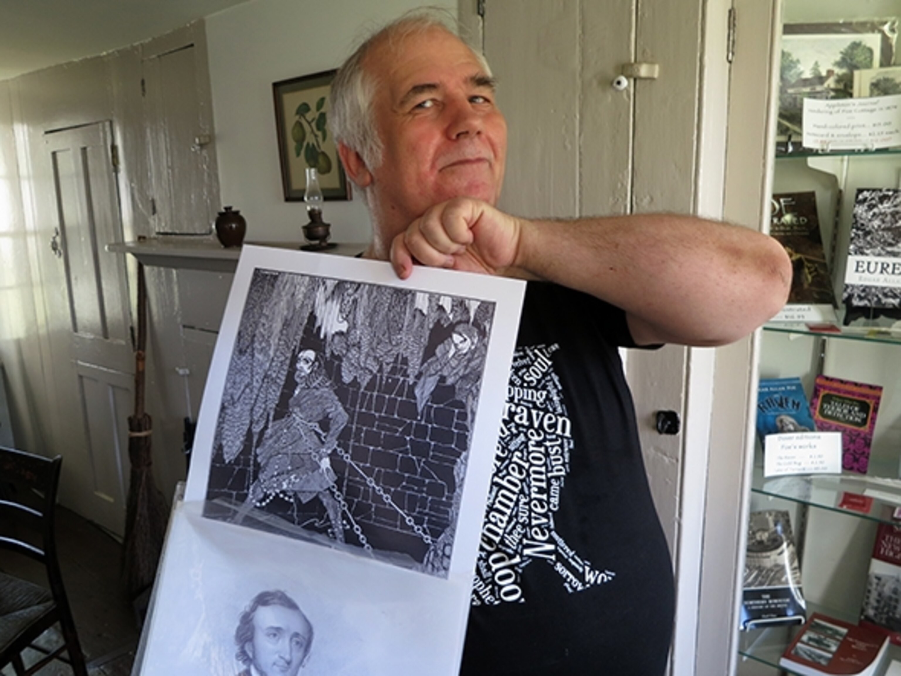 Neil Ralley holding up a print at  the Poe Cottage (Photograph by Robert Reid)