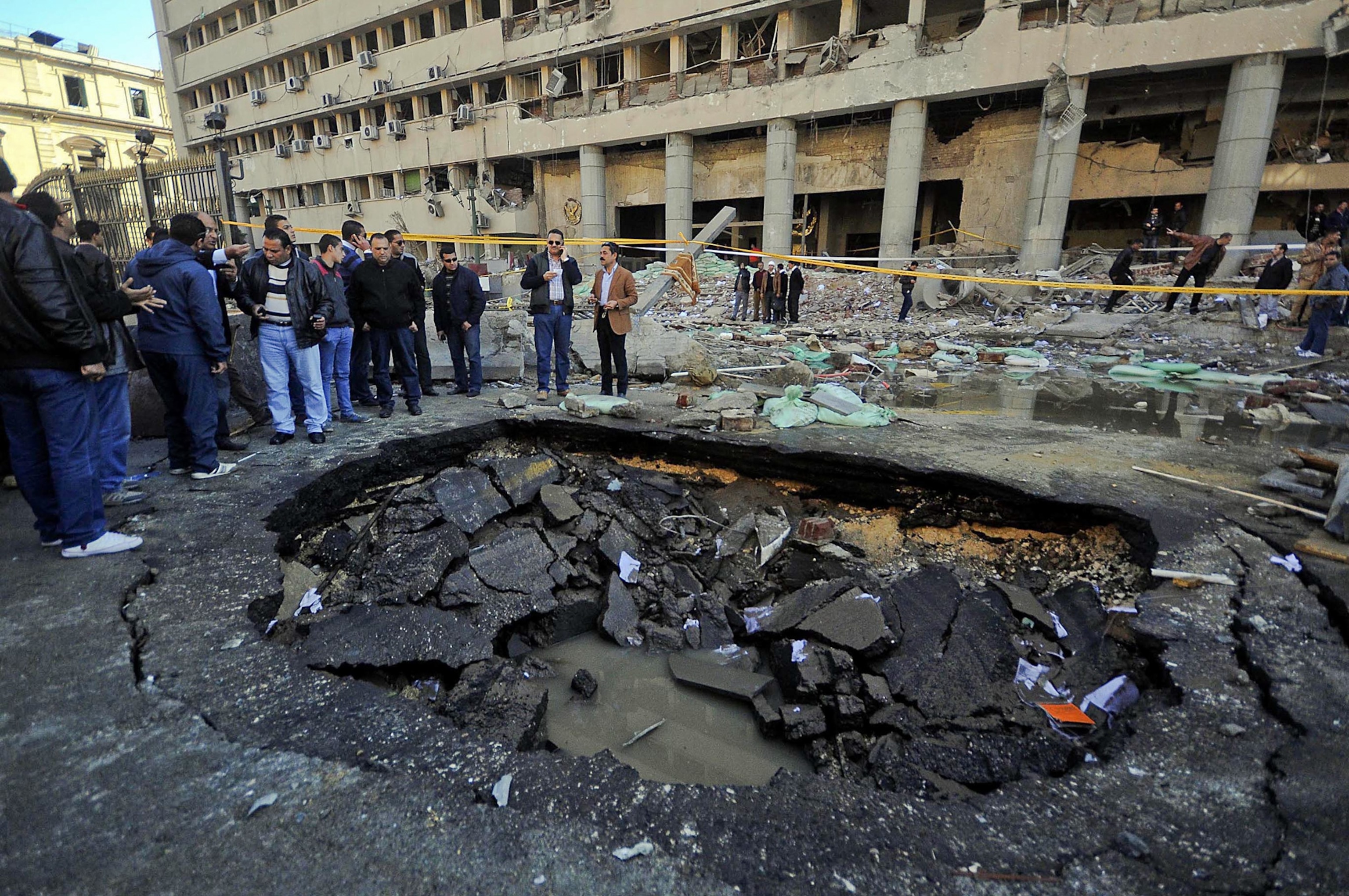 Egyptian security officers cordon off the site of a car bomb attack targeted Cairo security headquarters.