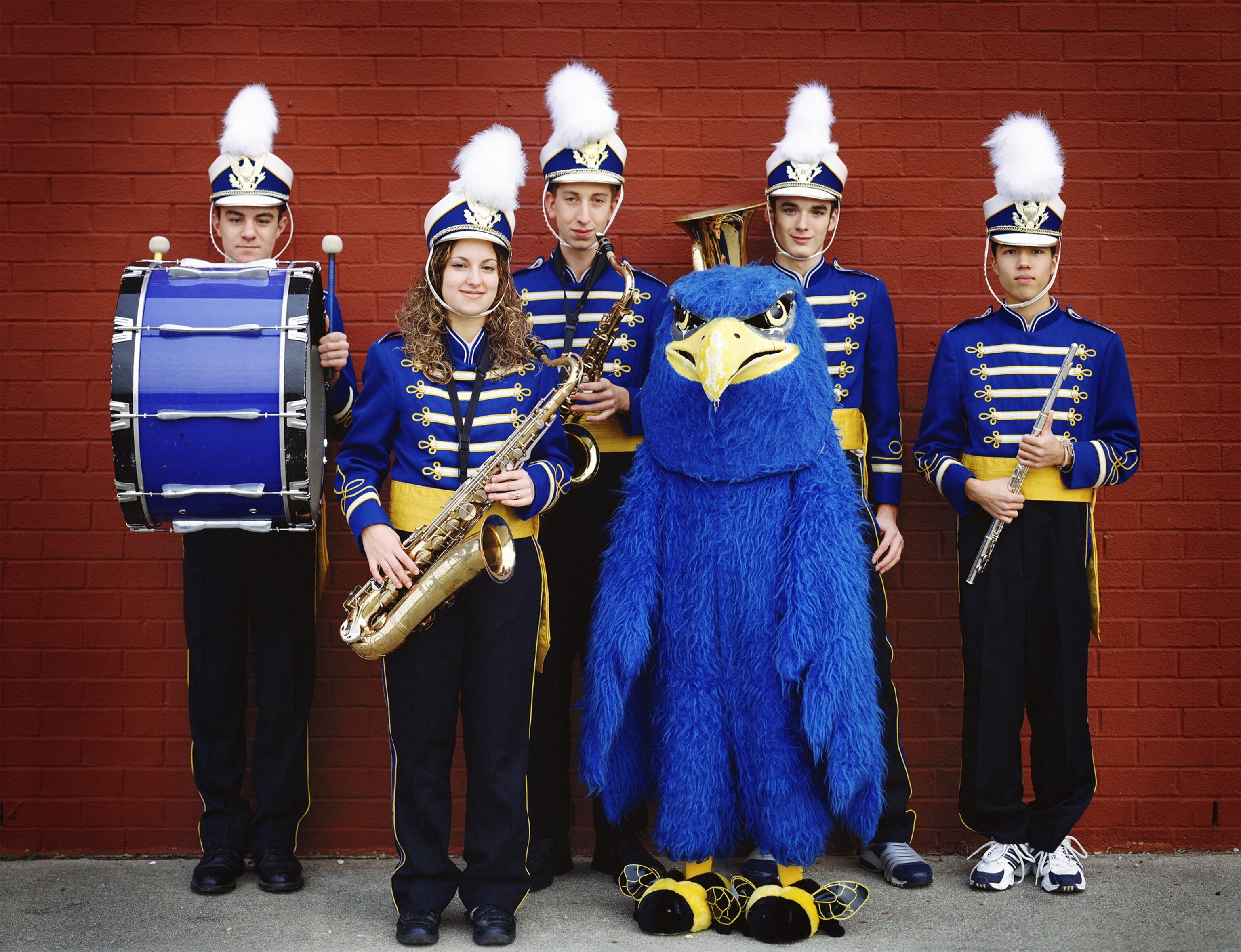A high school marching band poses with an eagle mascot.