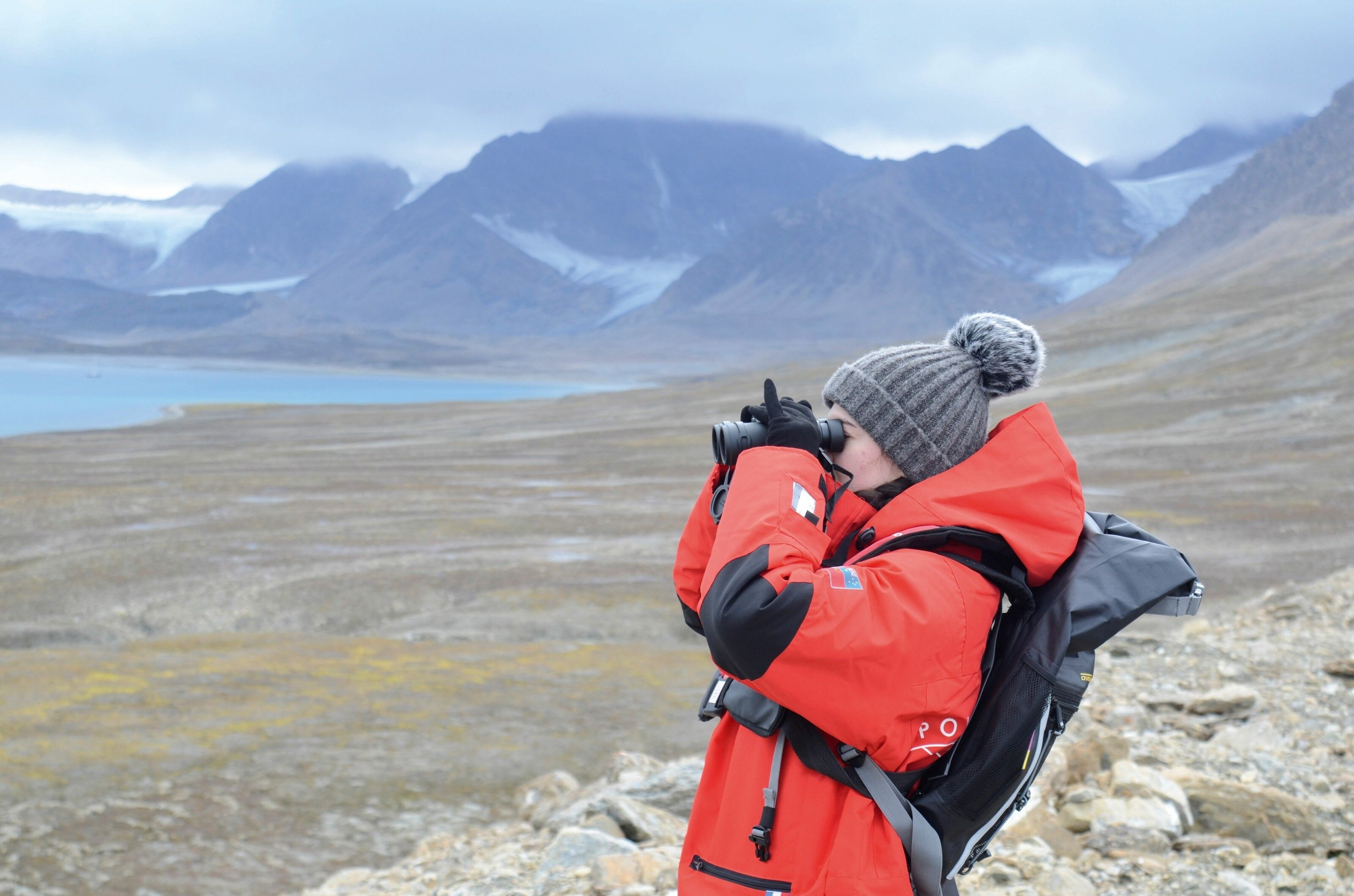 Wrapped in her thick arctic jacket, author Farida Zeynalova peers through a pair of binoculars, observing the landscape and abundant wildlife.