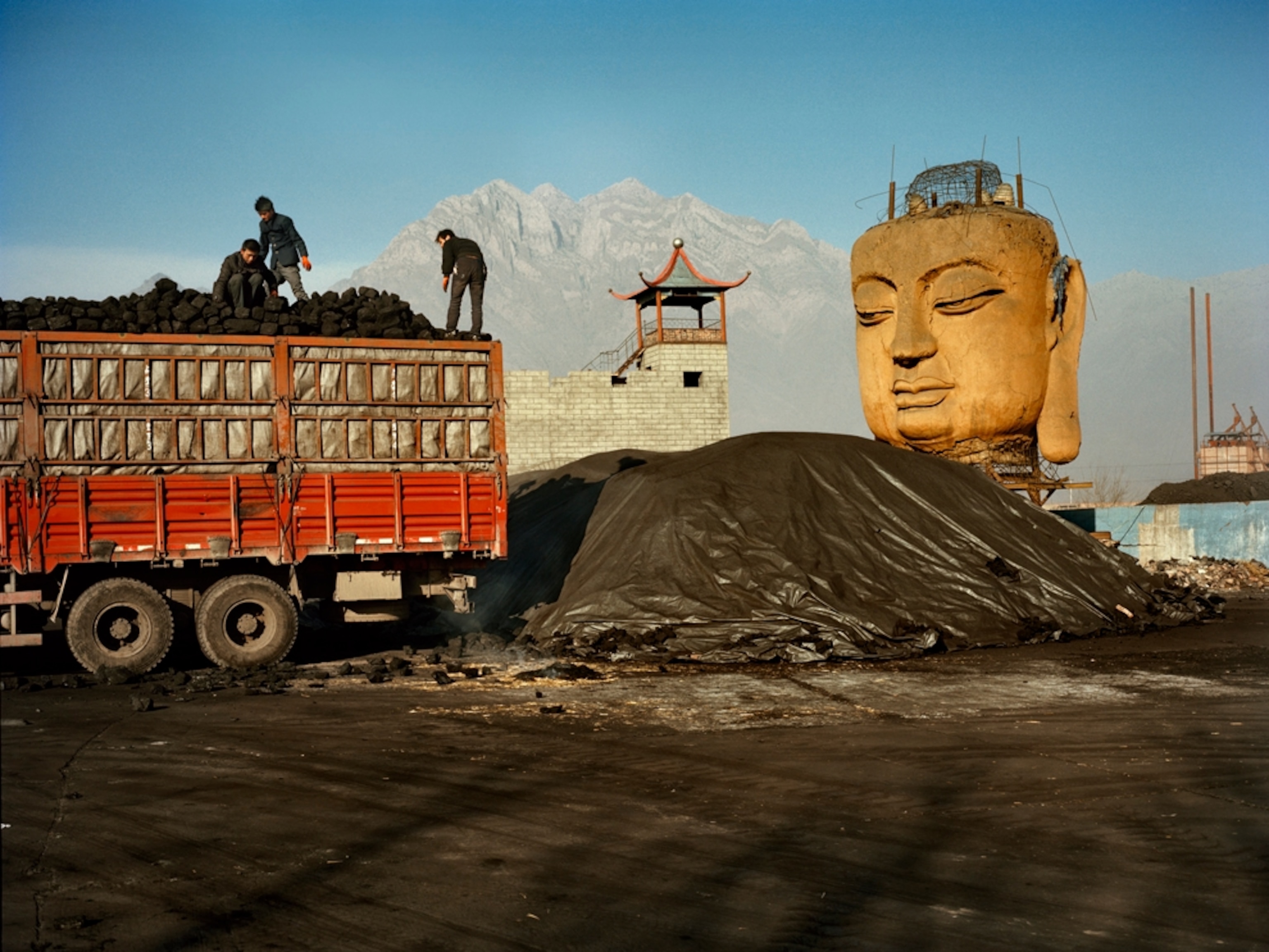 Coal yard in northern China with a Buddha statue