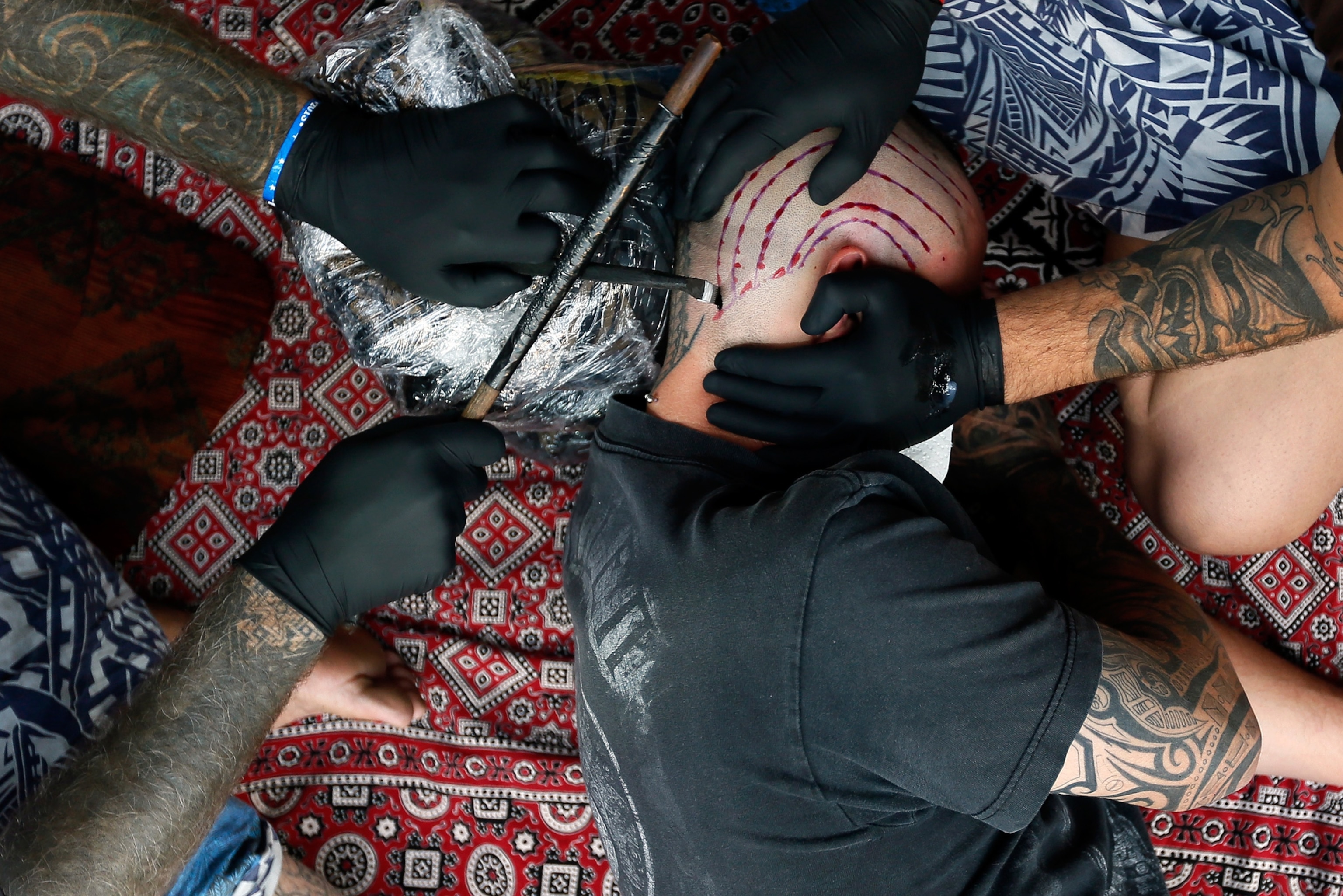 Pictures We Love - Picture of a tattoo artist working on a client's shaved head during the ninth London Tattoo Convention