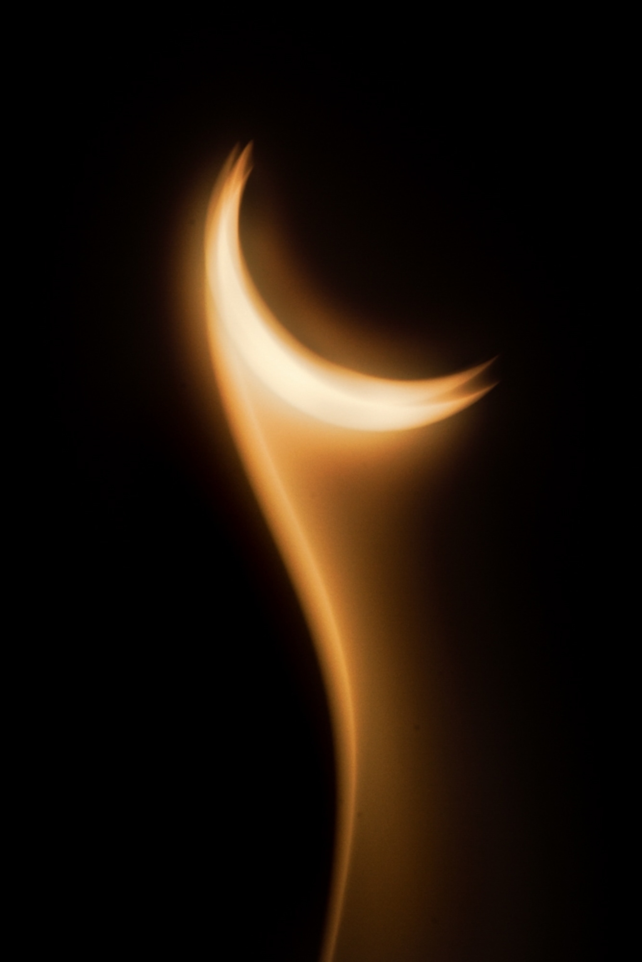 Glowing golden crescent-shaped light curves upward against a black background
