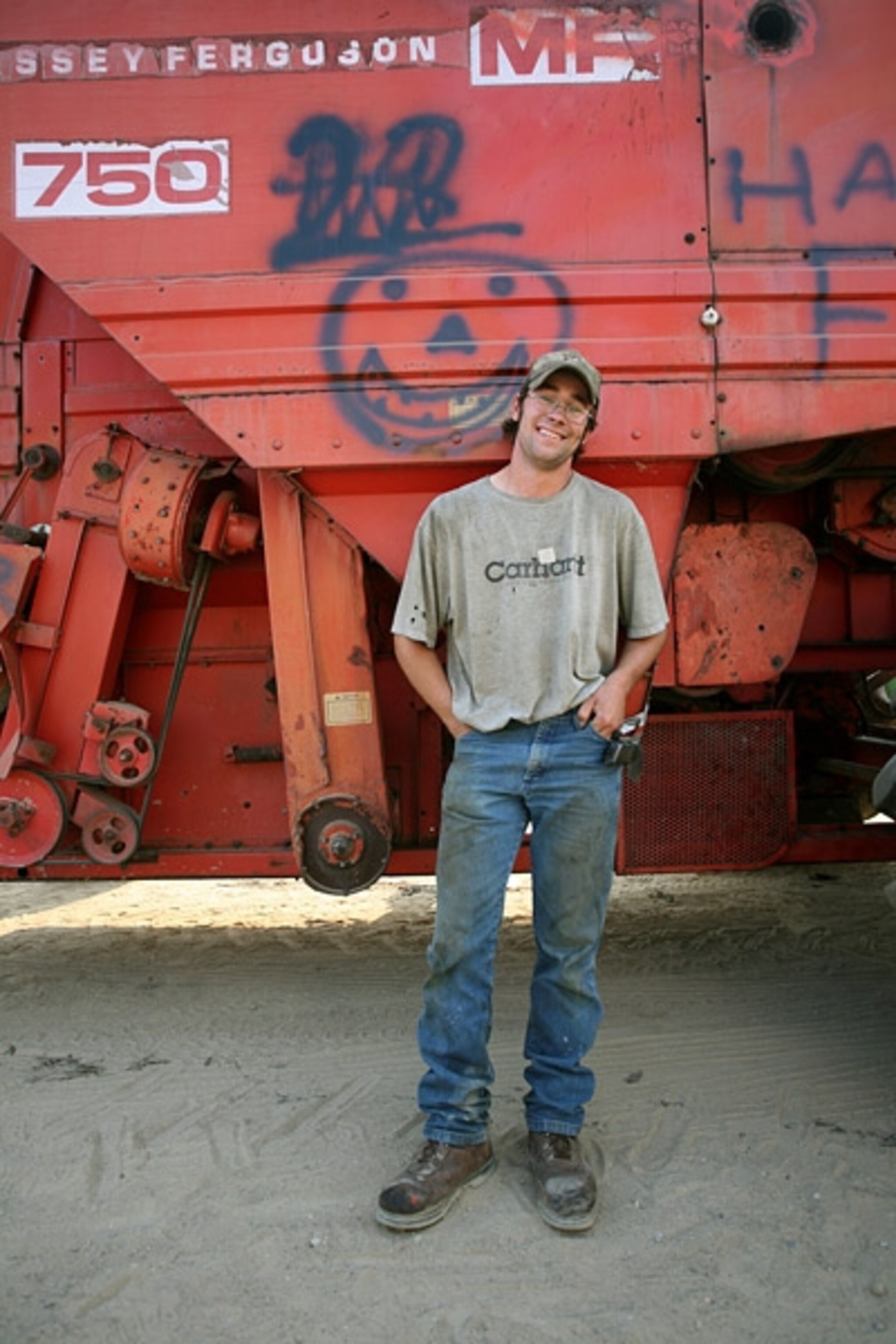 A man standing next to a red combine
