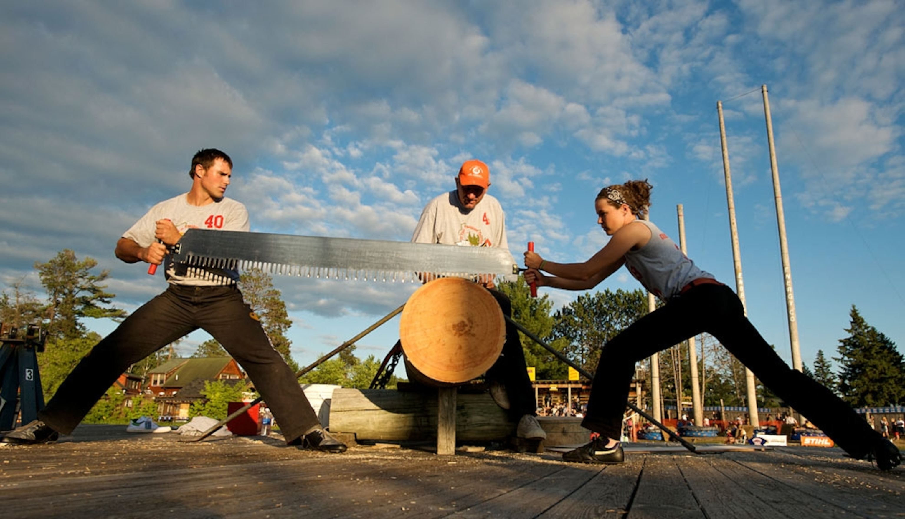 Man and woman sawing through tree
