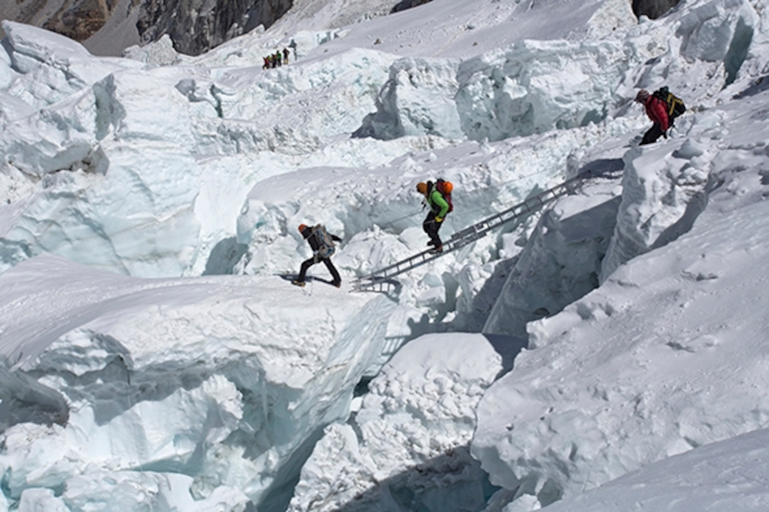 Sherpas and climbers negotiating the ladders and creavsses in the Khumbu Icefall on Everest on the Nepal side. Two years ago today, on April 18, 2014, an avalanche killed 16 Nepali mountain workers in the Khumbu Icefall; Photograph by Jonathan Griffith/Aurora