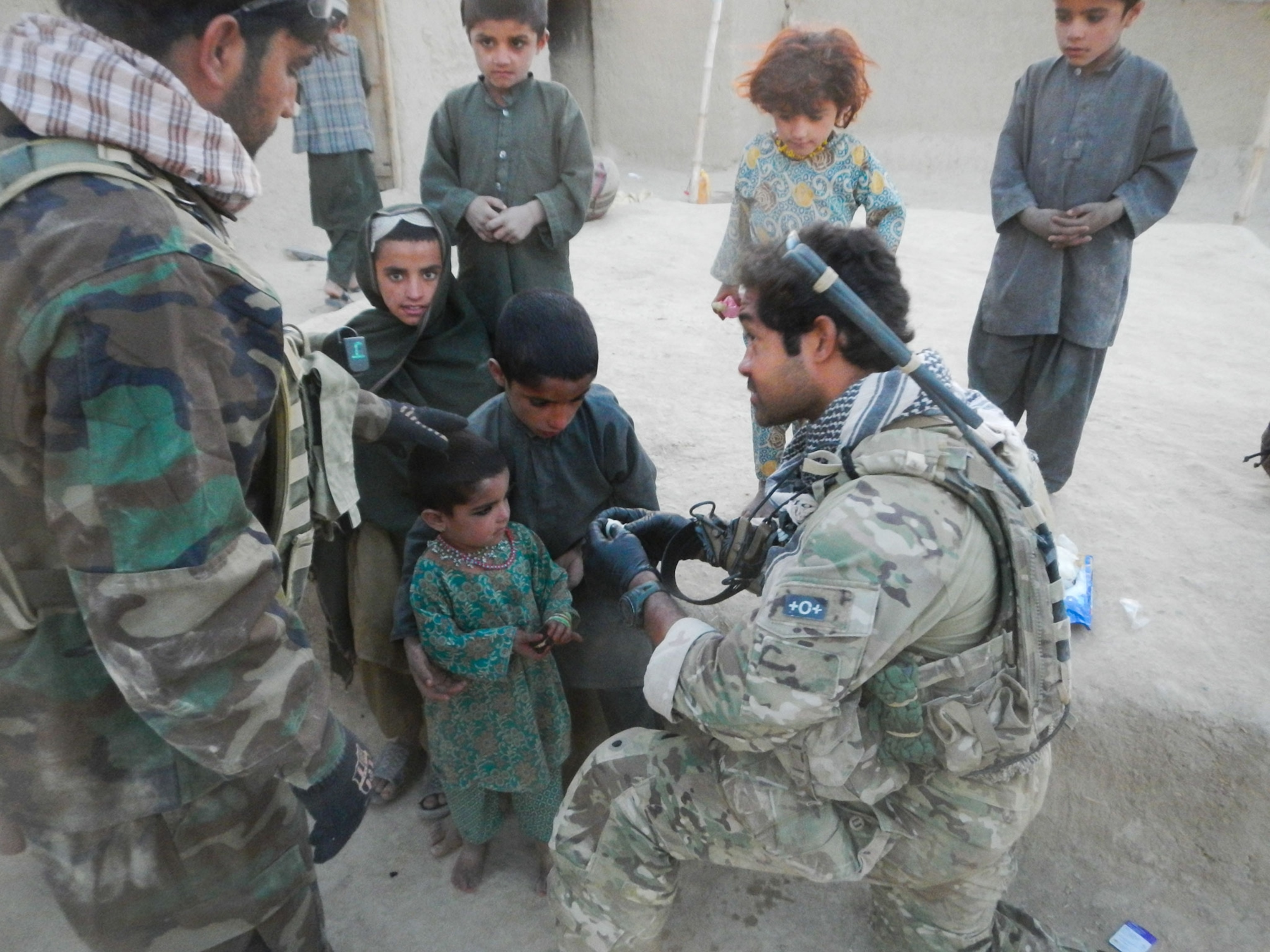 Master Sergeant Ivan Ruiz treating an Afghan child's infected eye