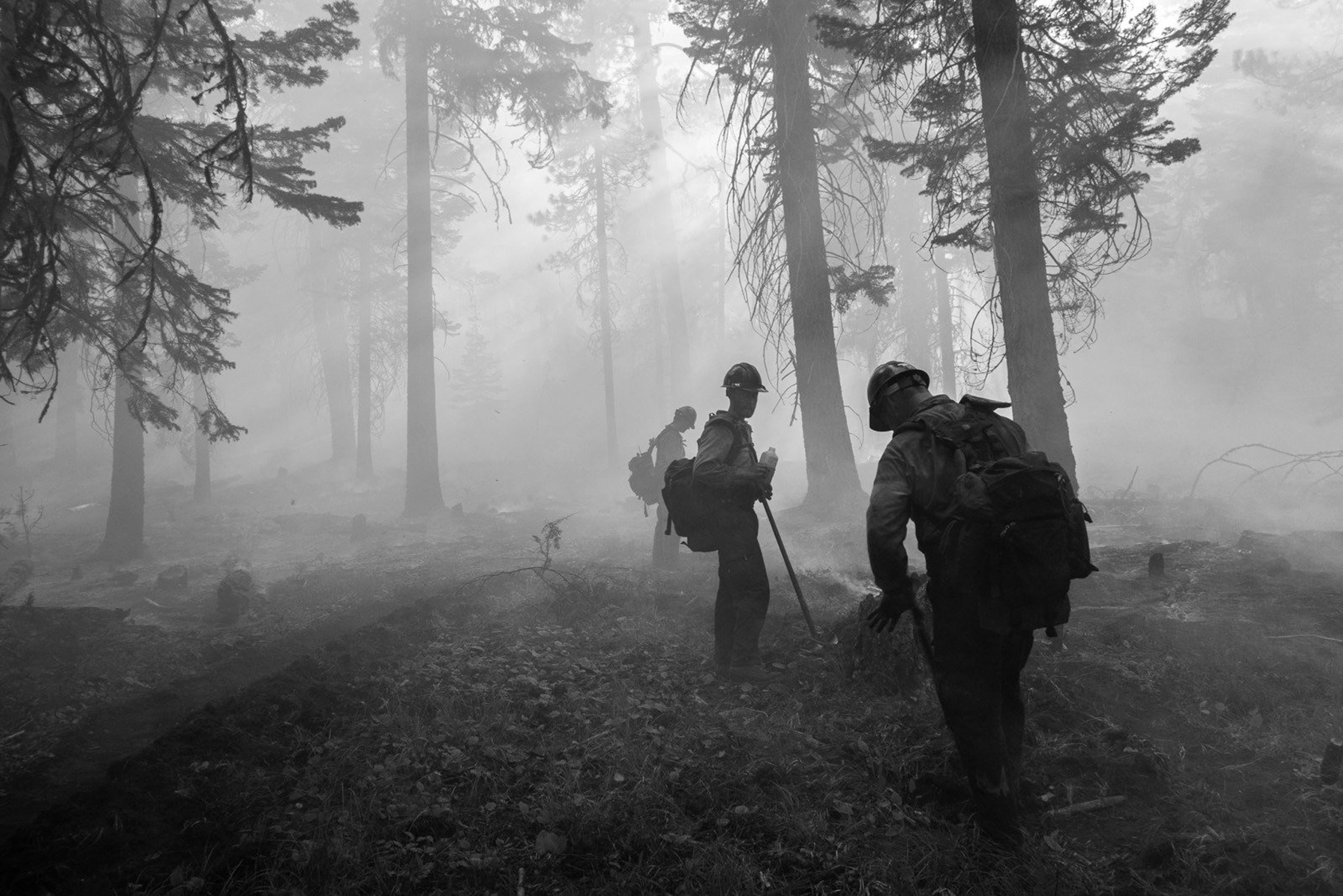 members of a Hotshot crew stopping to drink water in the smoke.
