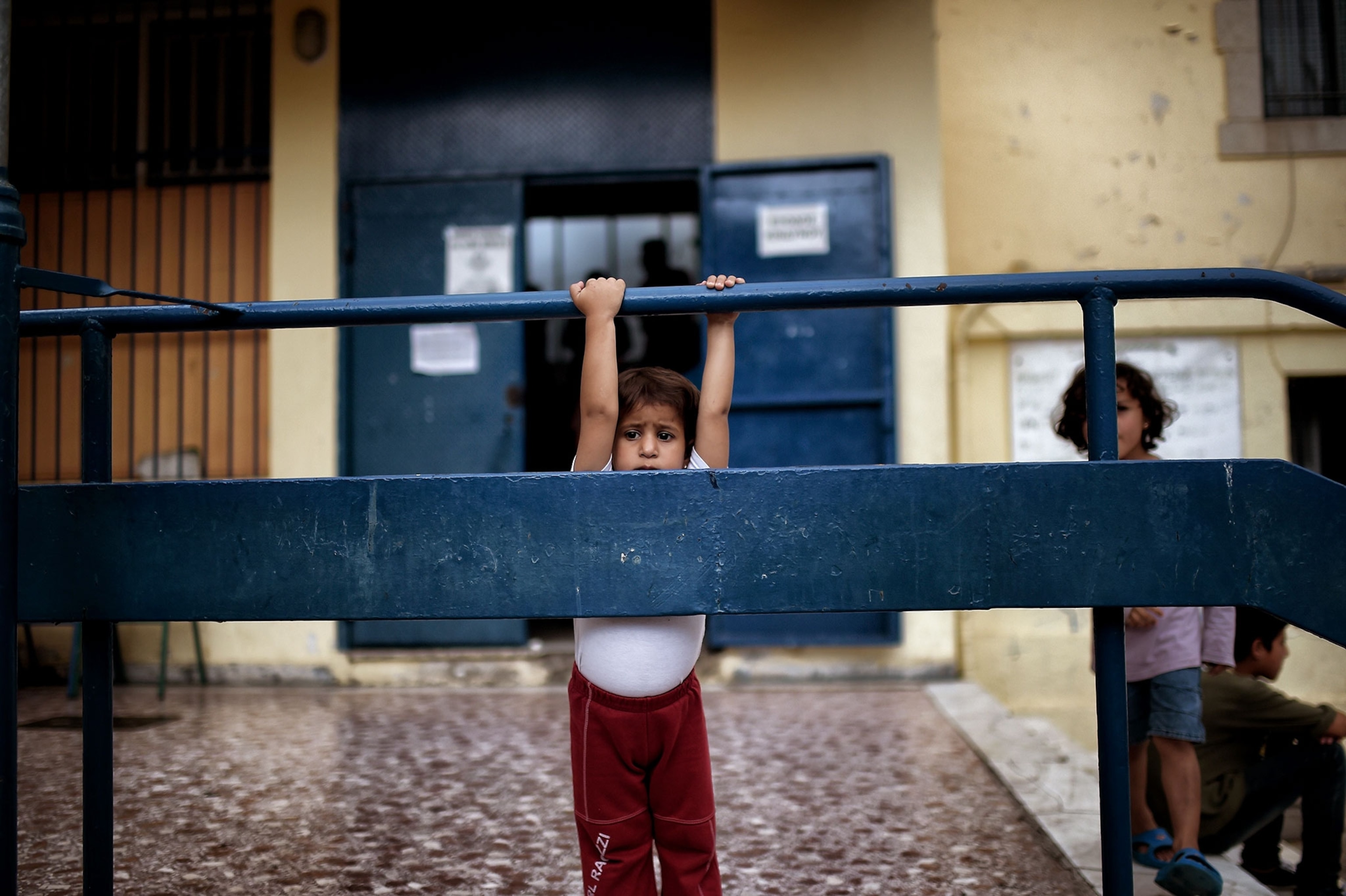 a child in a courtyard at a school in Athens