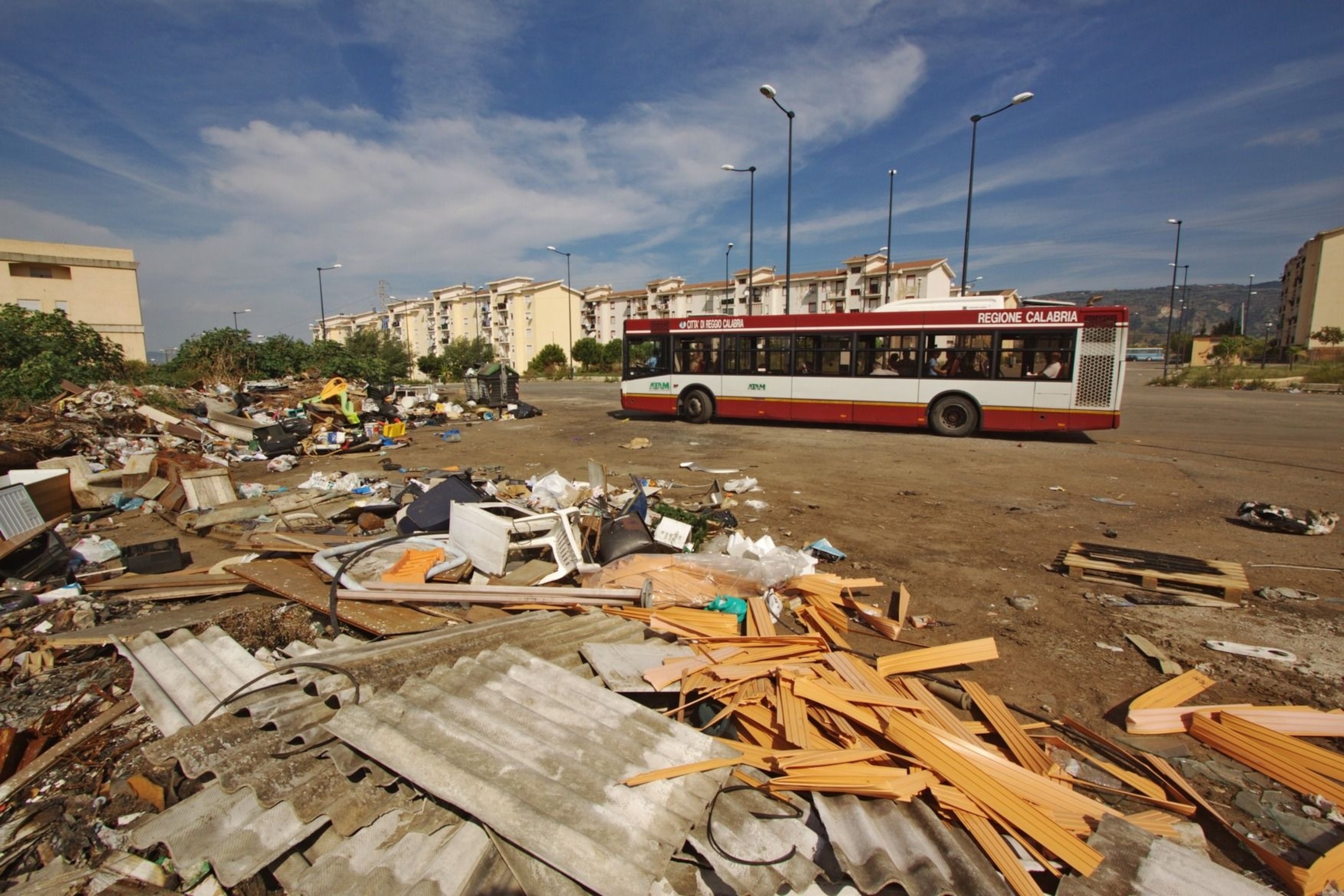 A public bas passes by a lot strewn with carcinogenic waste