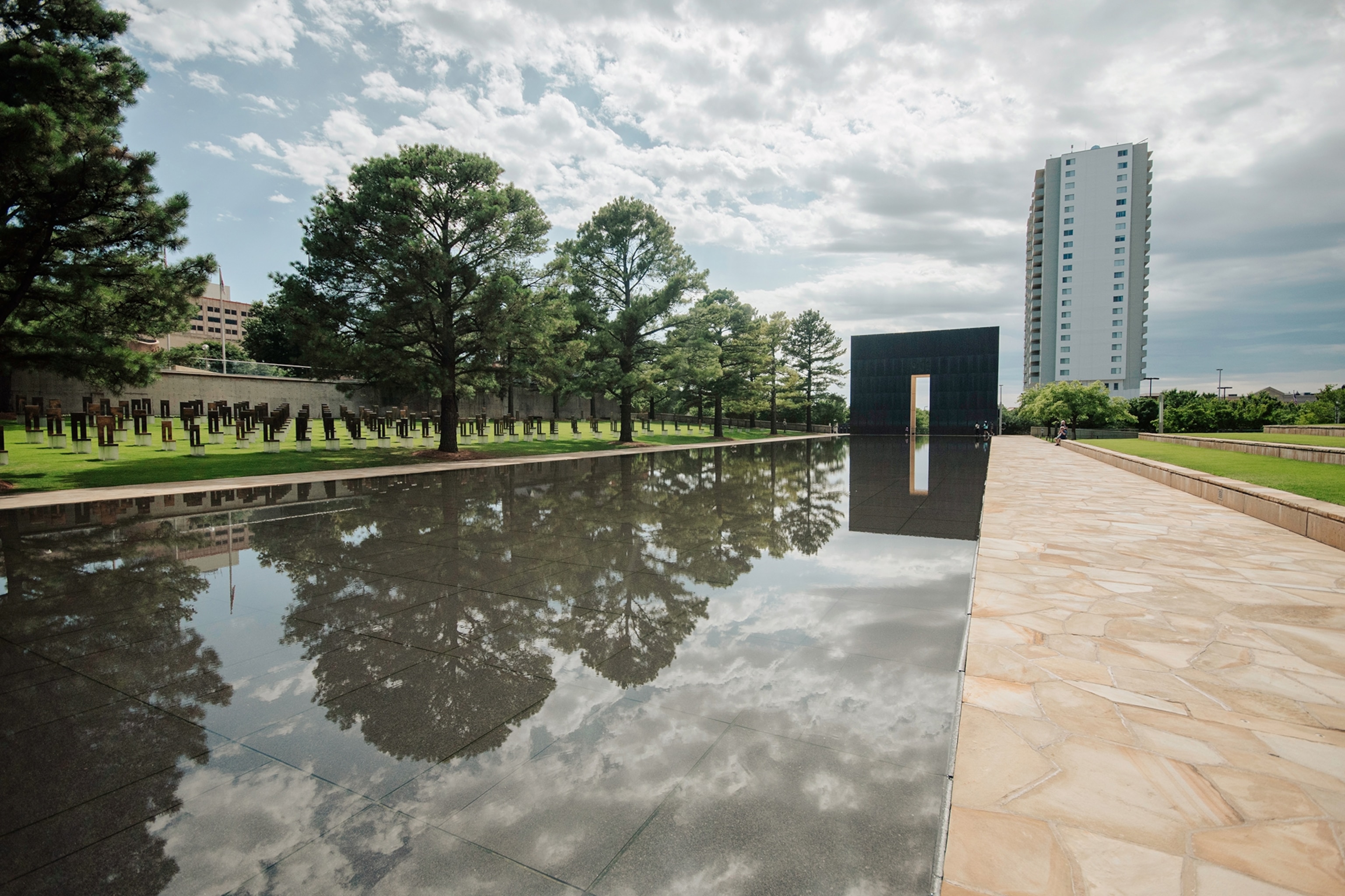 Trees and clouds are reflected in the water of the Oklahoma City National Memorial and Museum.